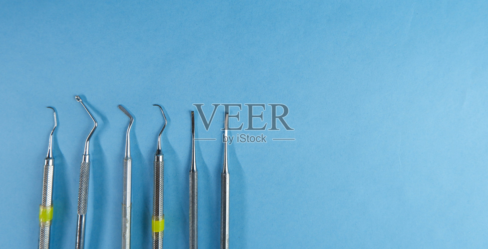 一套蓝色背景的牙科工具，颌骨模型，牙科工具和牙刷照片摄影图片