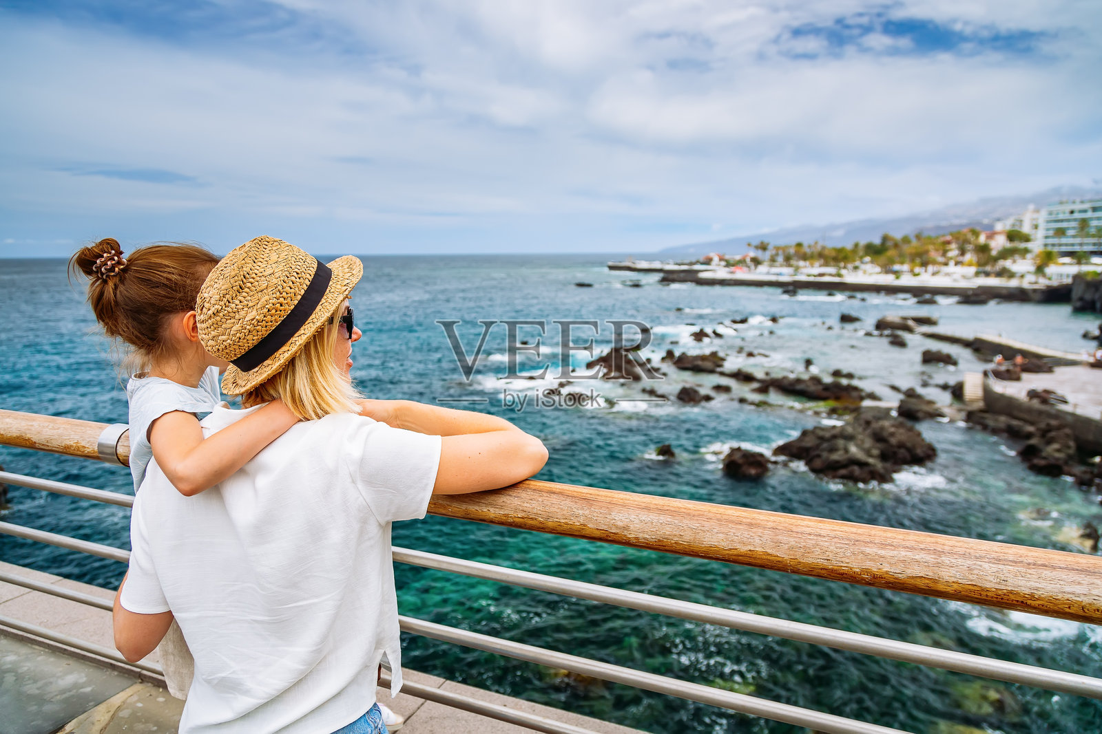 母女俩站在一起，看着德拉克鲁兹港的堤岸照片摄影图片