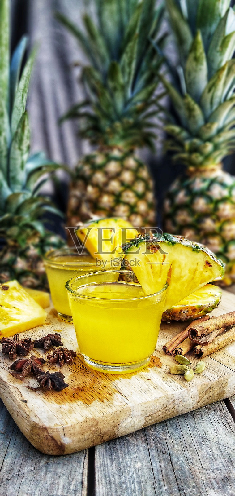 杯子里的菠萝汁放在砧板上照片摄影图片