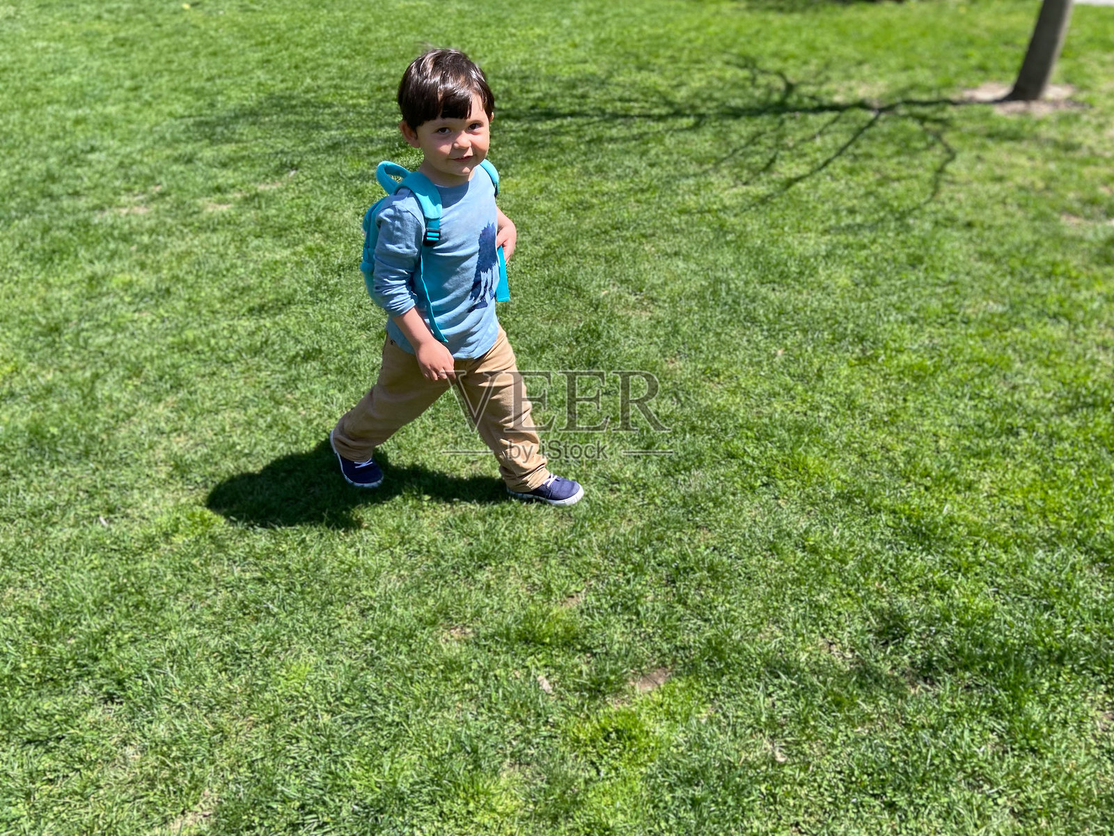 男孩走在草地上照片摄影图片