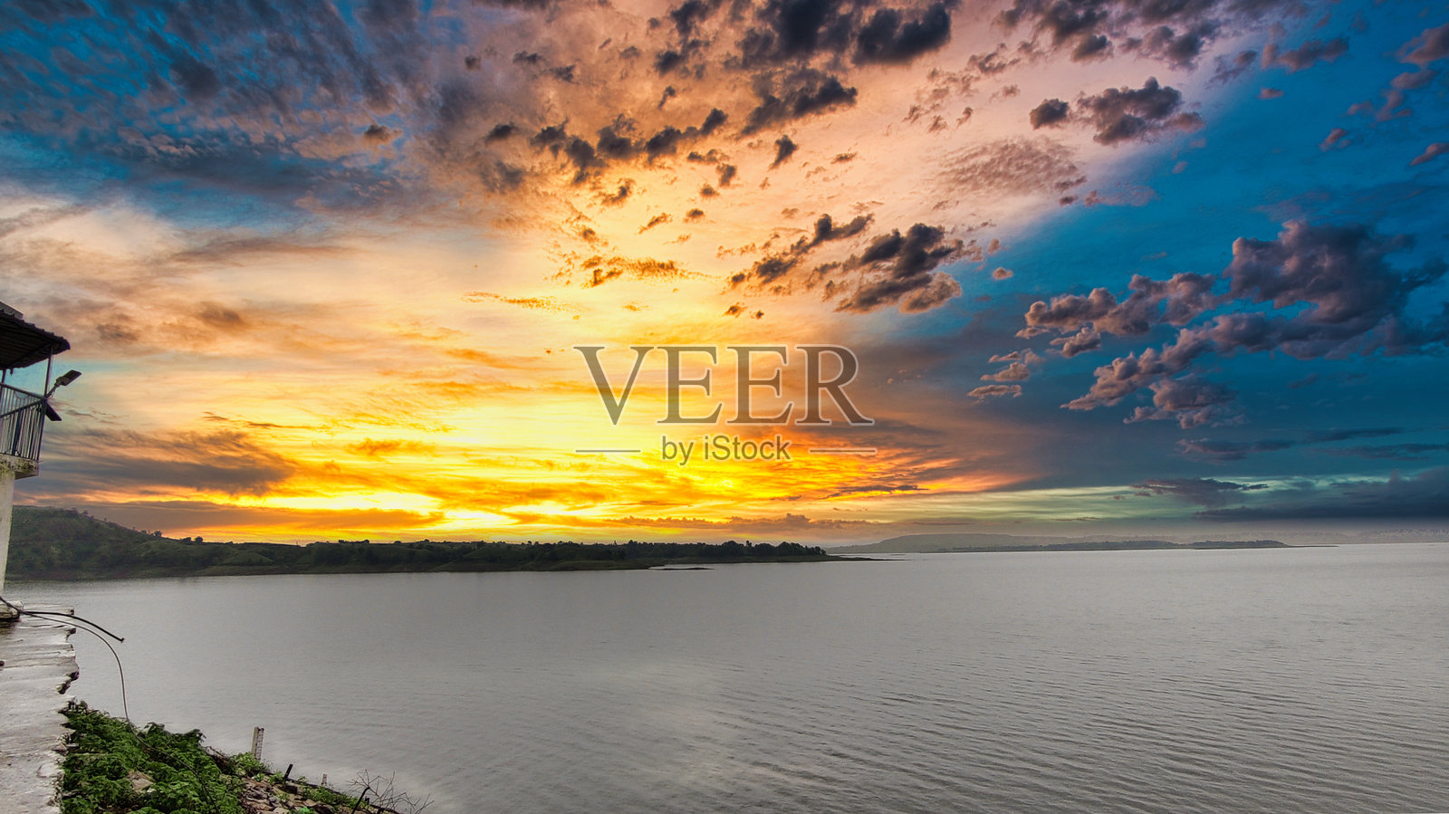 日落时分湖泊、丘陵和树木的景观照片摄影图片