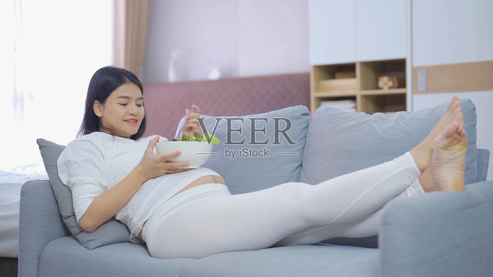 幸福的亚洲孕妇在家里的卧室里吃沙拉蔬菜食品节食的肖像。生孩子了。家庭人的生活方式。妈妈的爱。照片摄影图片