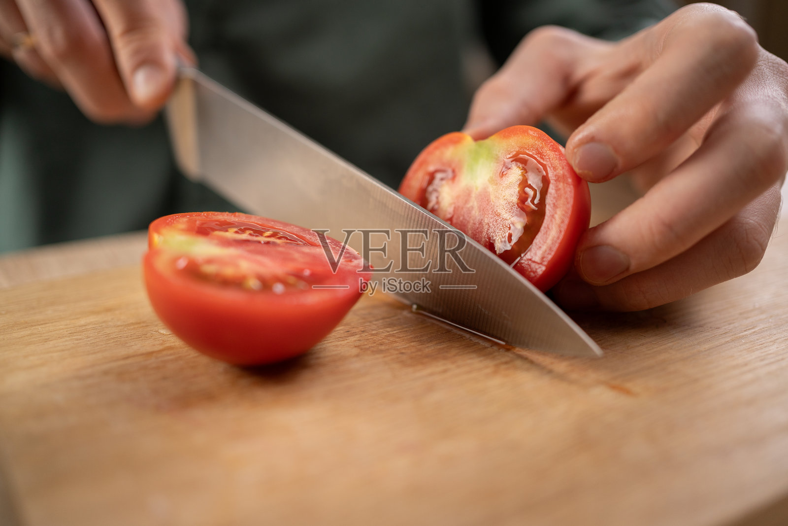 厨师用大刀切红番茄，选择性聚焦，概念居家烹饪照片摄影图片