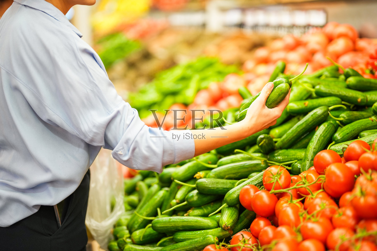 一个女人在杂货店过道里用手买水果和蔬菜的特写照片摄影图片