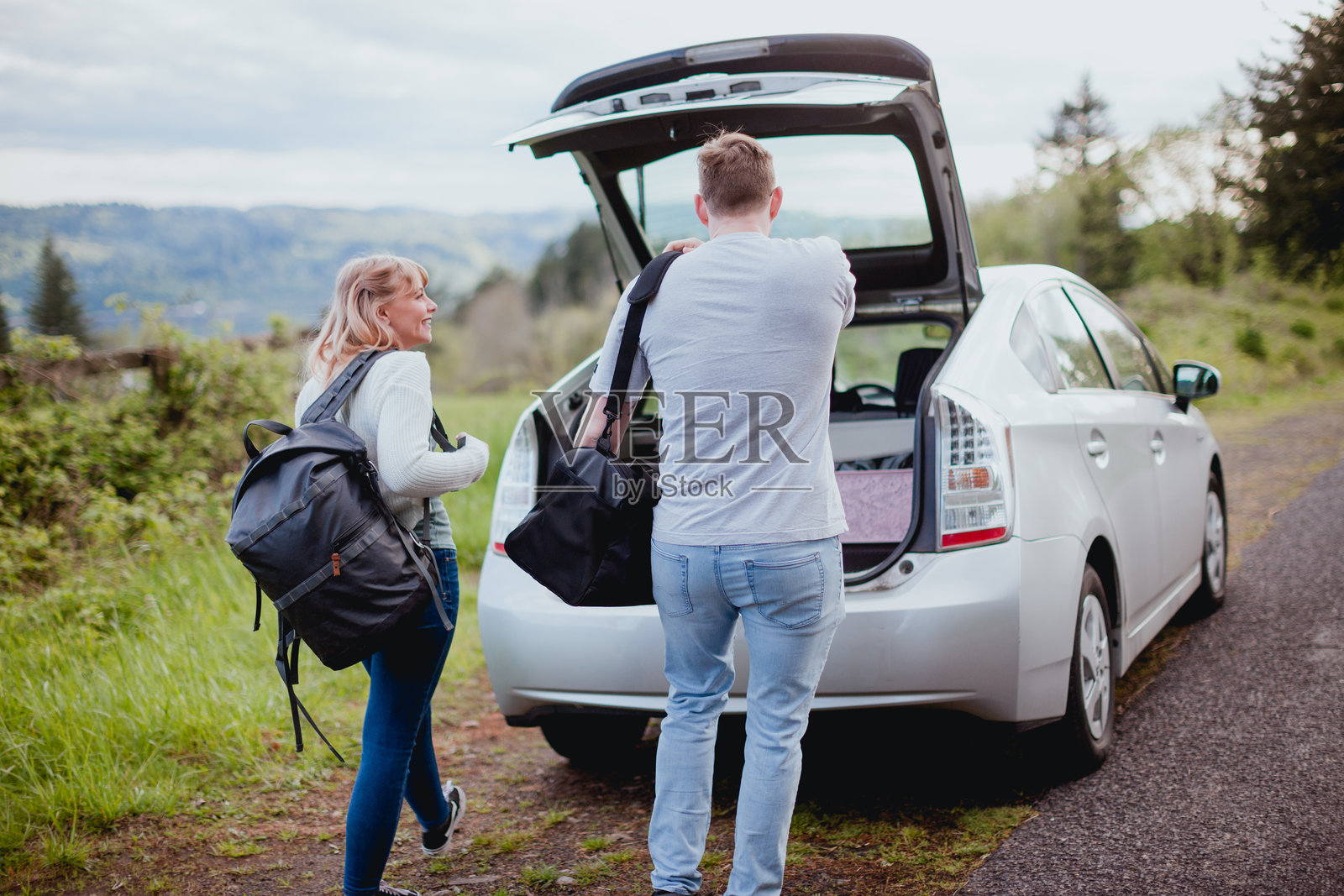年轻的夫妇正在装车，准备进行一场充满爱的公路旅行照片摄影图片