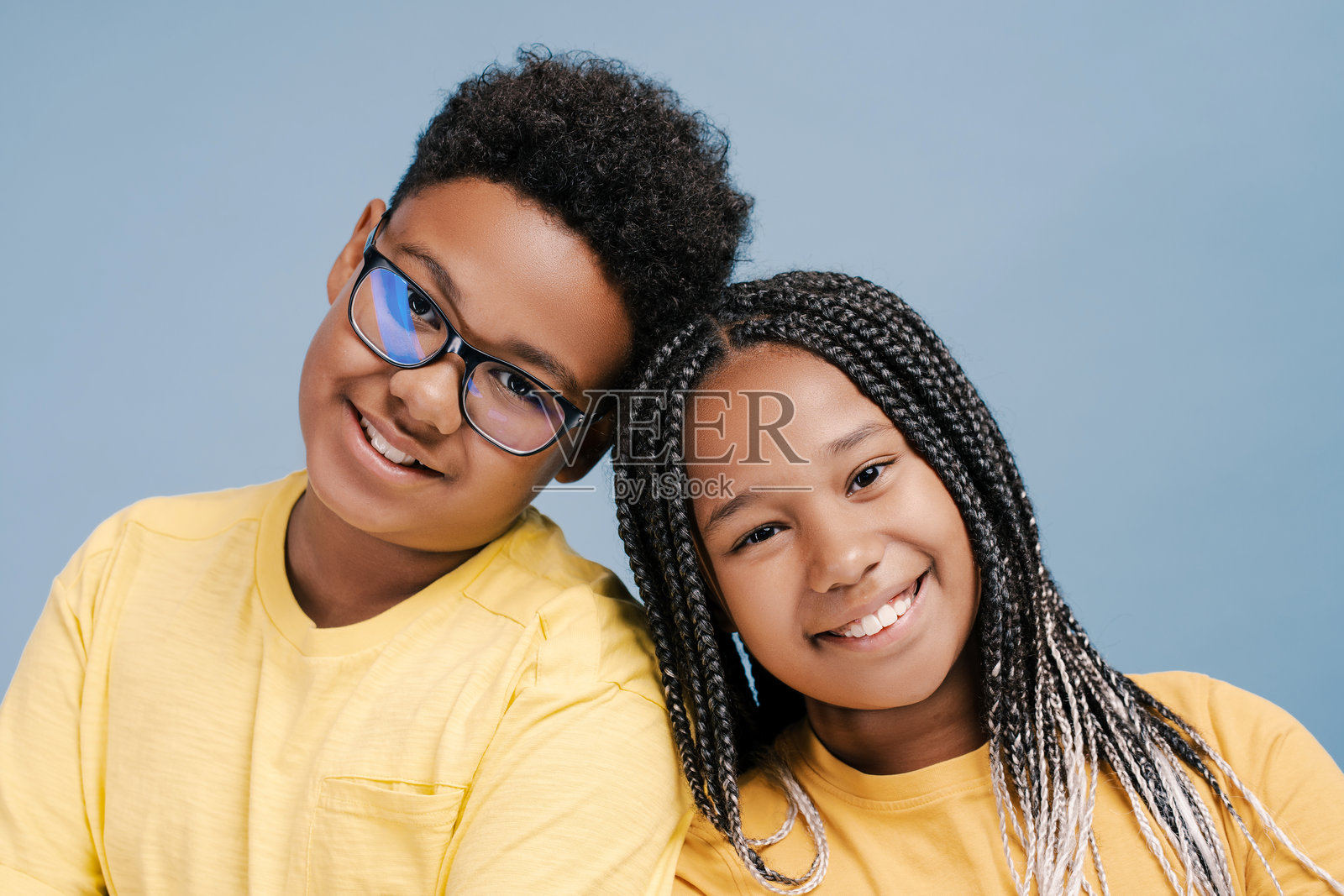 微笑着的非裔美国孩子们聚在一起看着镜头，孤立地看着蓝色照片摄影图片