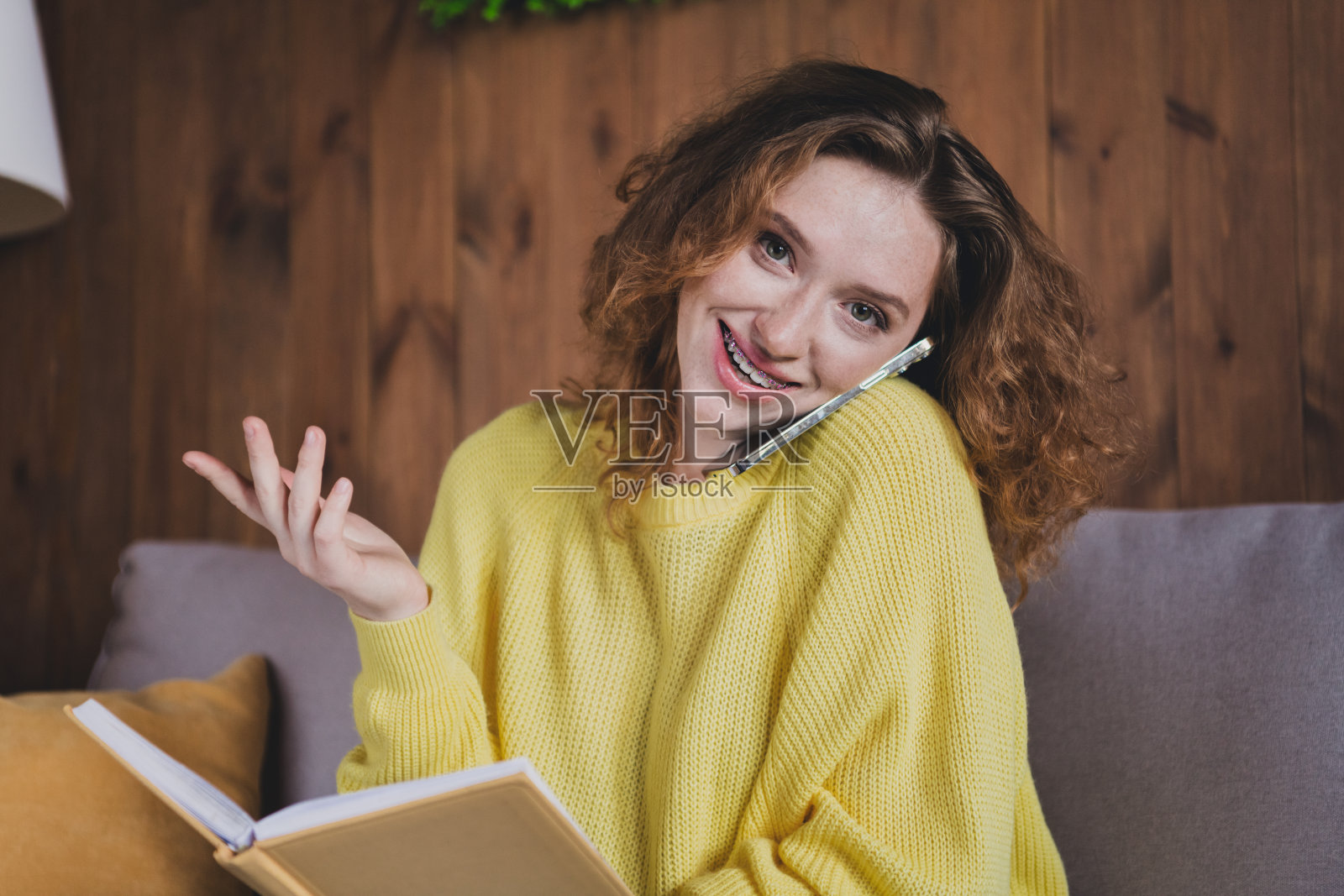 照片迷人的年轻女性通话电话笔记本穿着黄色毛衣舒适的日光家室内客厅照片摄影图片