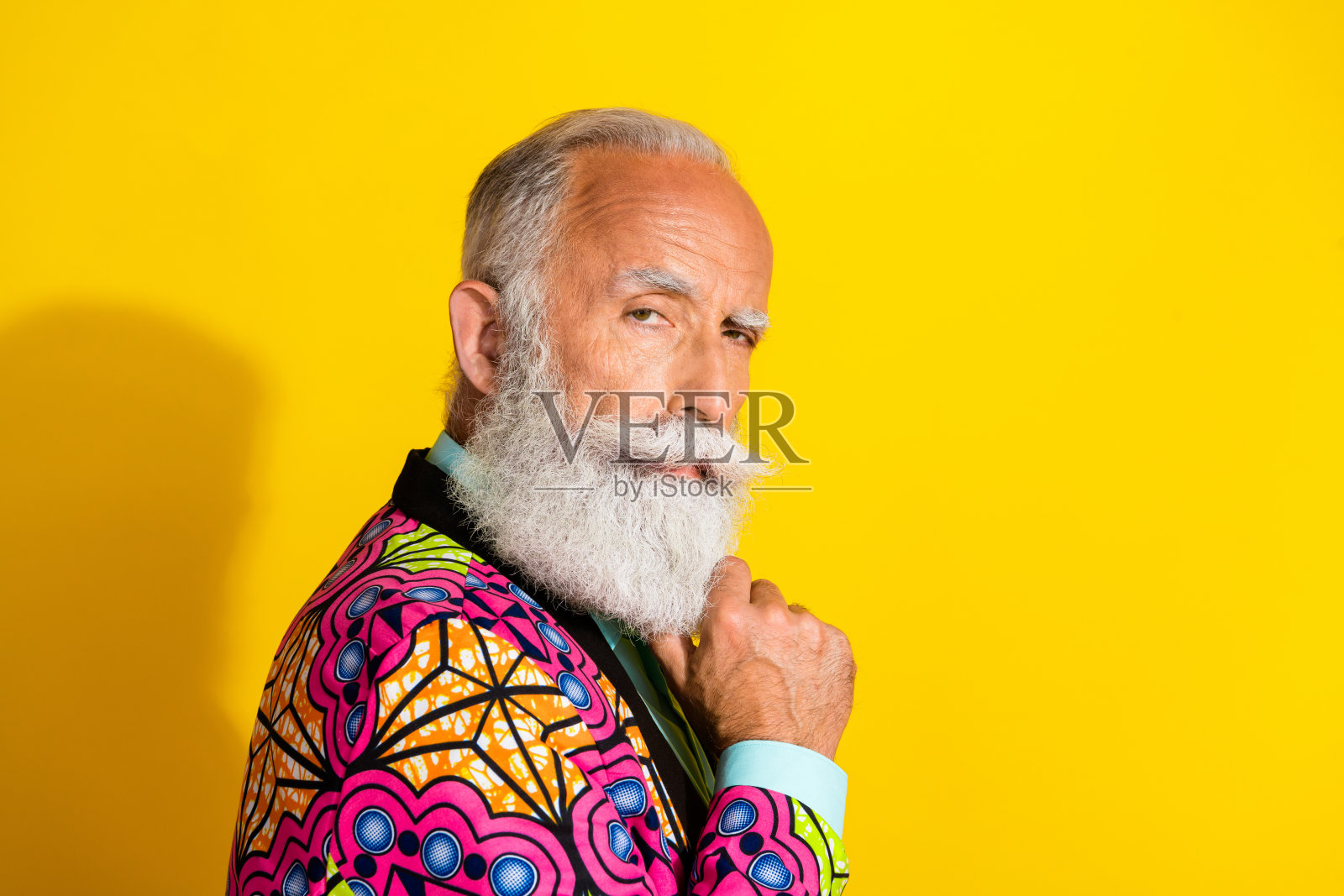 照片肖像漂亮的高级男性看起来头脑严肃的相机穿着时髦的彩色粉红色花式服装孤立在黄色的背景照片摄影图片