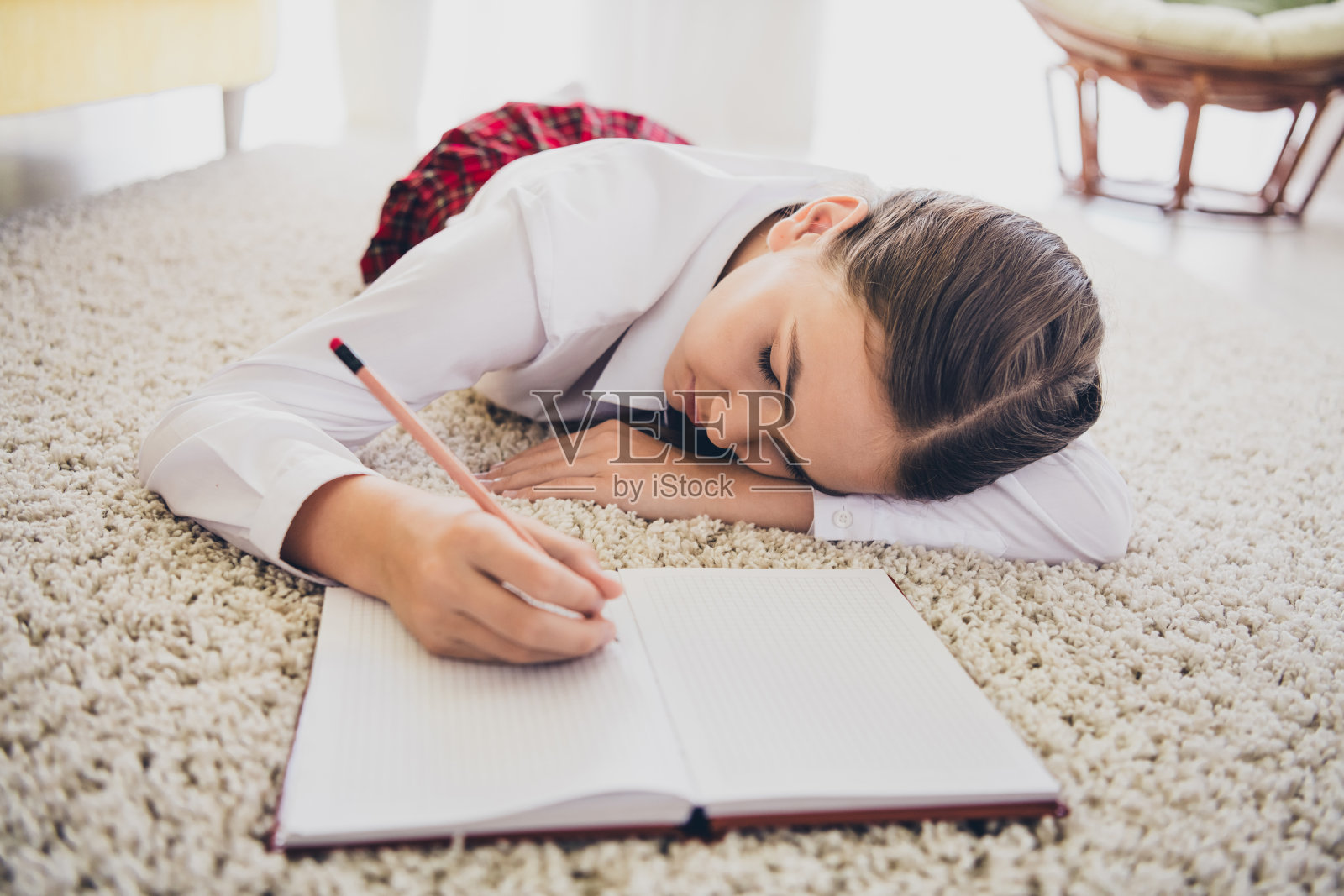 十几岁可爱女儿的全尺寸照片躺在地板上写笔记本睡觉穿校服远程教育家庭教育室内背景照片摄影图片