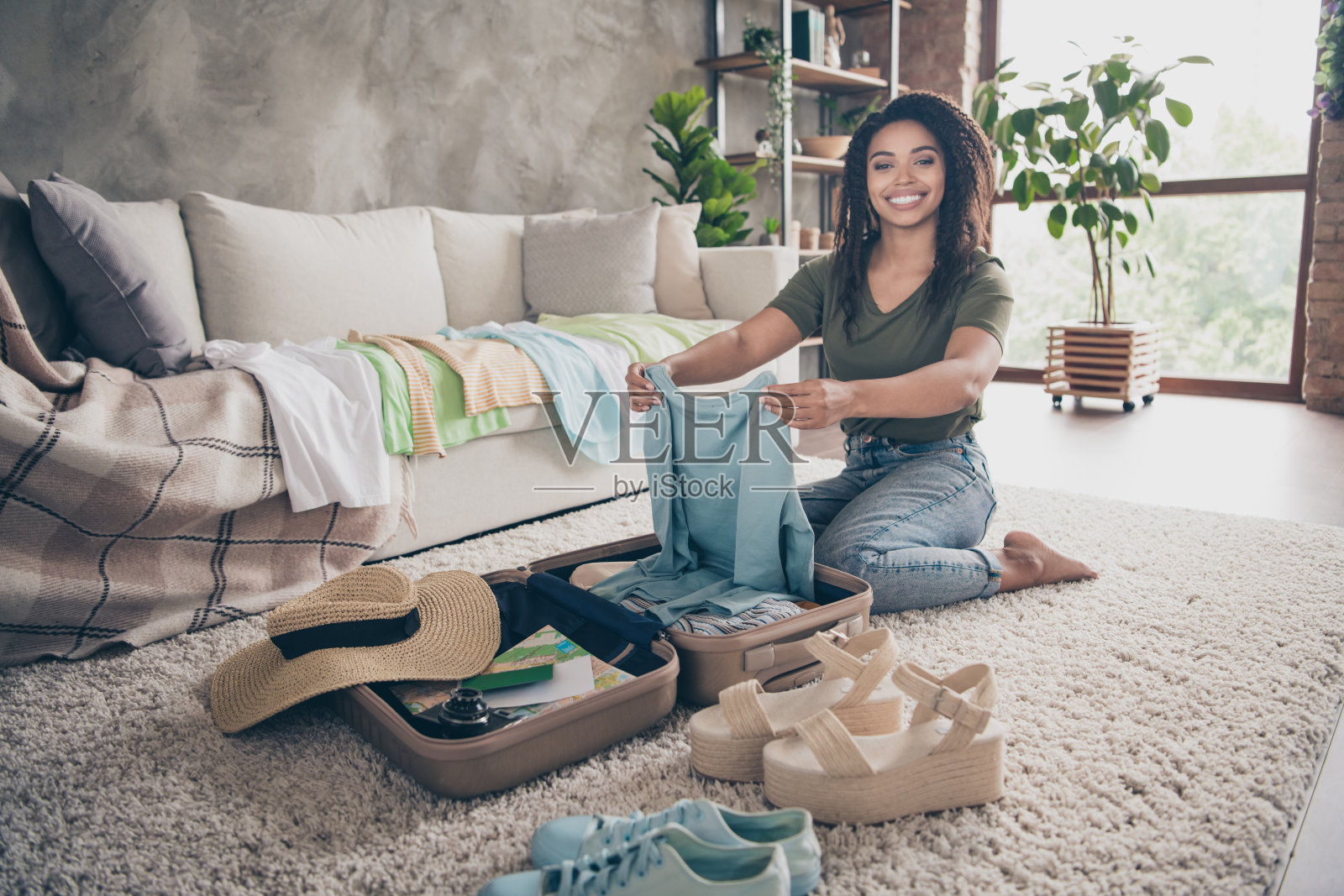 照片积极的好心情的女人穿着绿色的t恤包装衣服夏天旅行室内房子公寓房间照片摄影图片