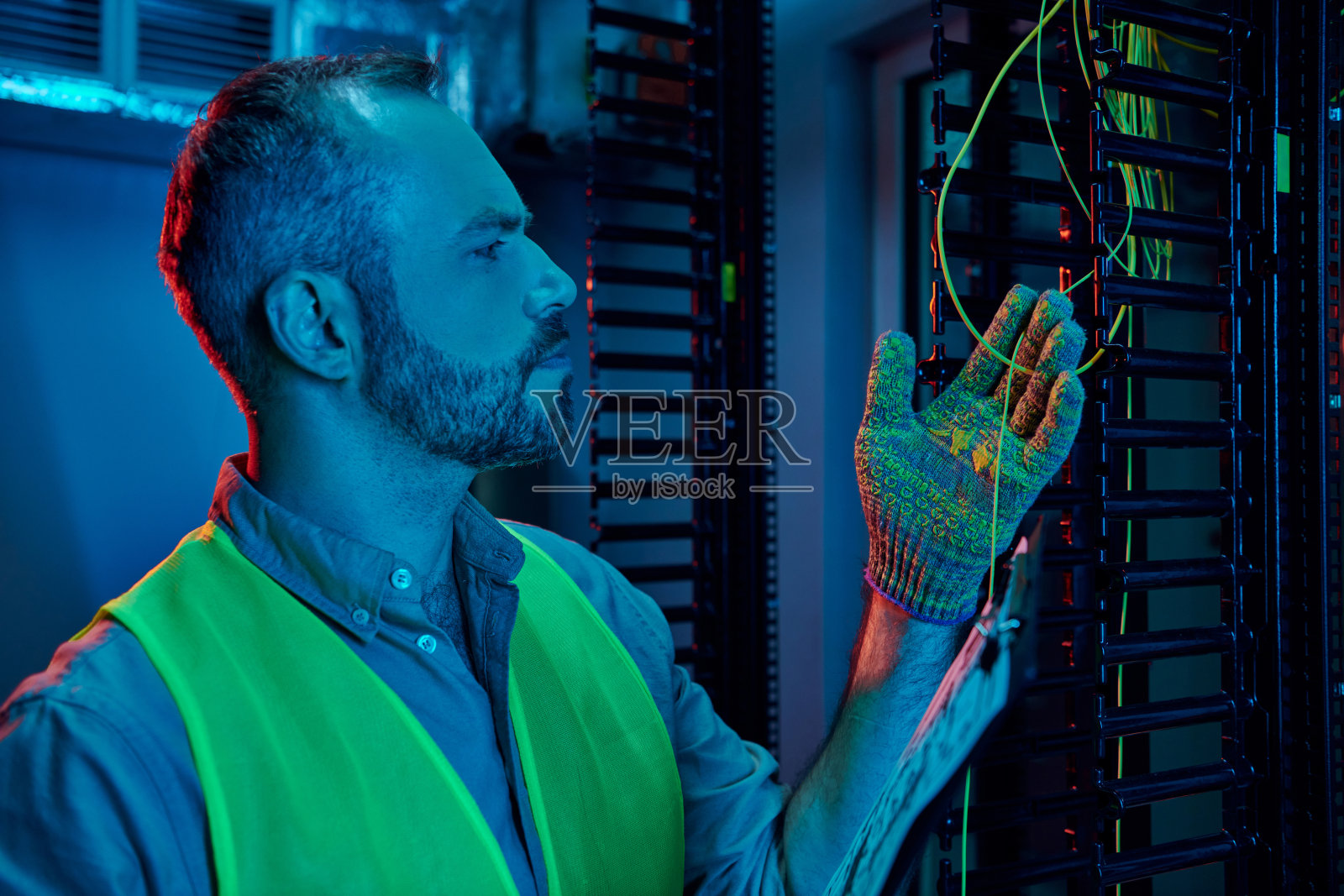 现代数据中心的熟练技术人员仔细管理复杂的布线系统照片摄影图片