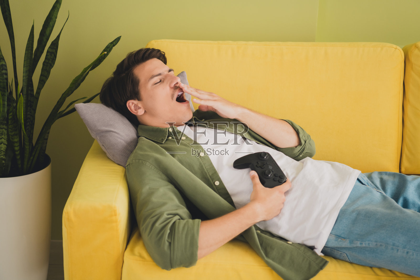 昏昏欲睡，疲惫，迷人的男人躺在舒适的沙发度假现代室内家庭房子的照片照片摄影图片