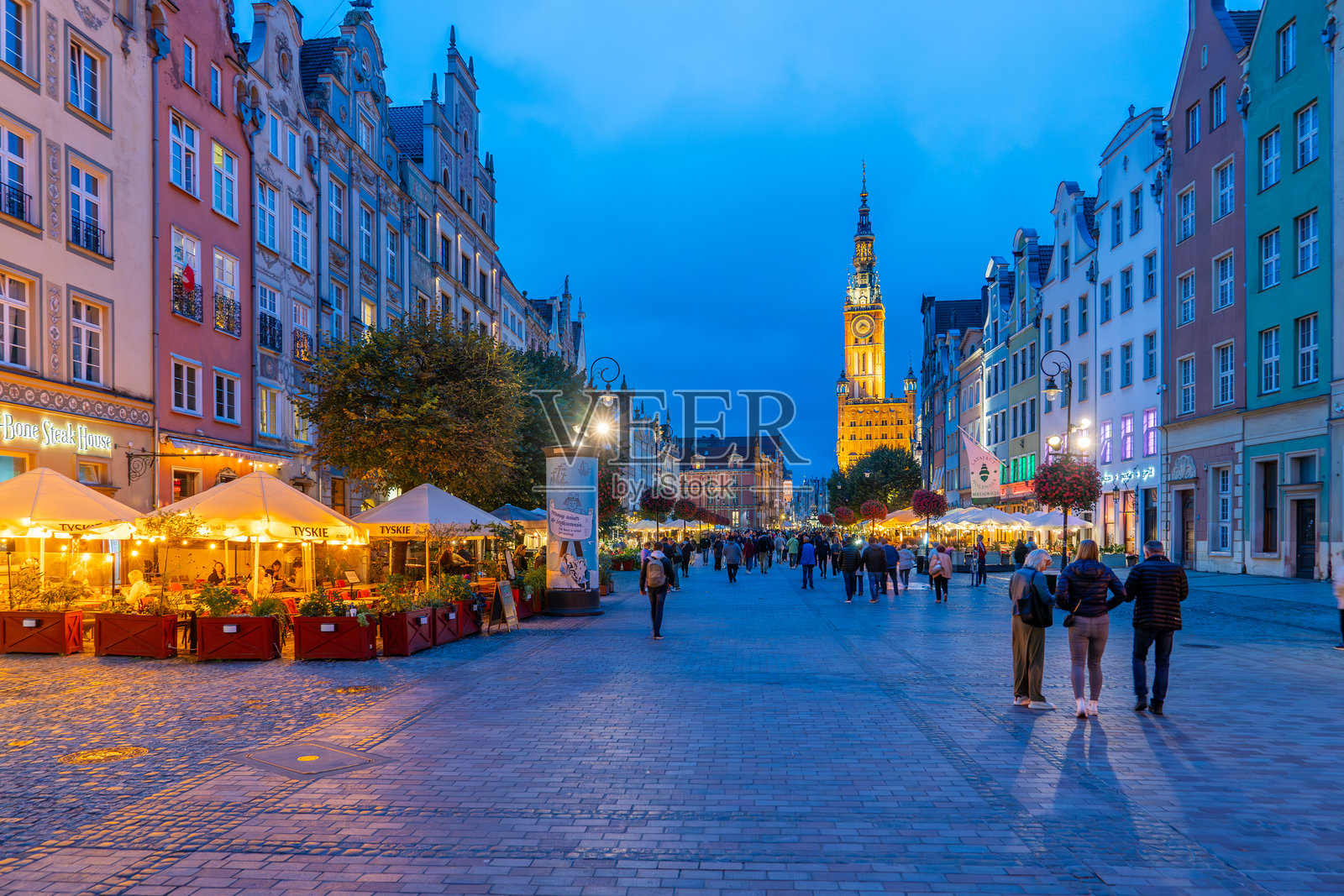 Ulica的夜景Długa在Gdańsk，户外餐厅和历史建筑在晴朗的蓝天下。照片摄影图片