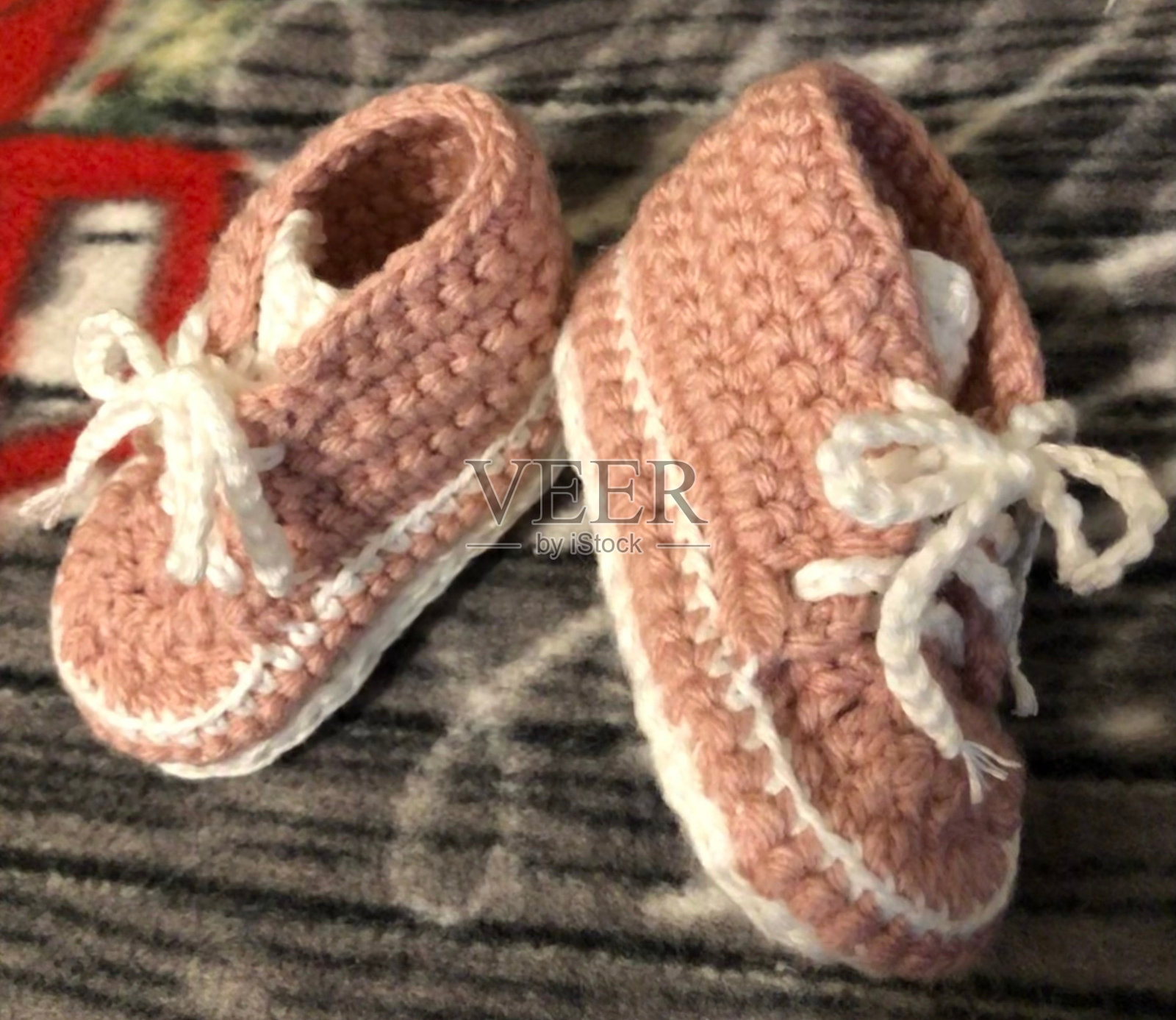 特写钩针婴儿靴在粉红色与白色鞋带照片摄影图片