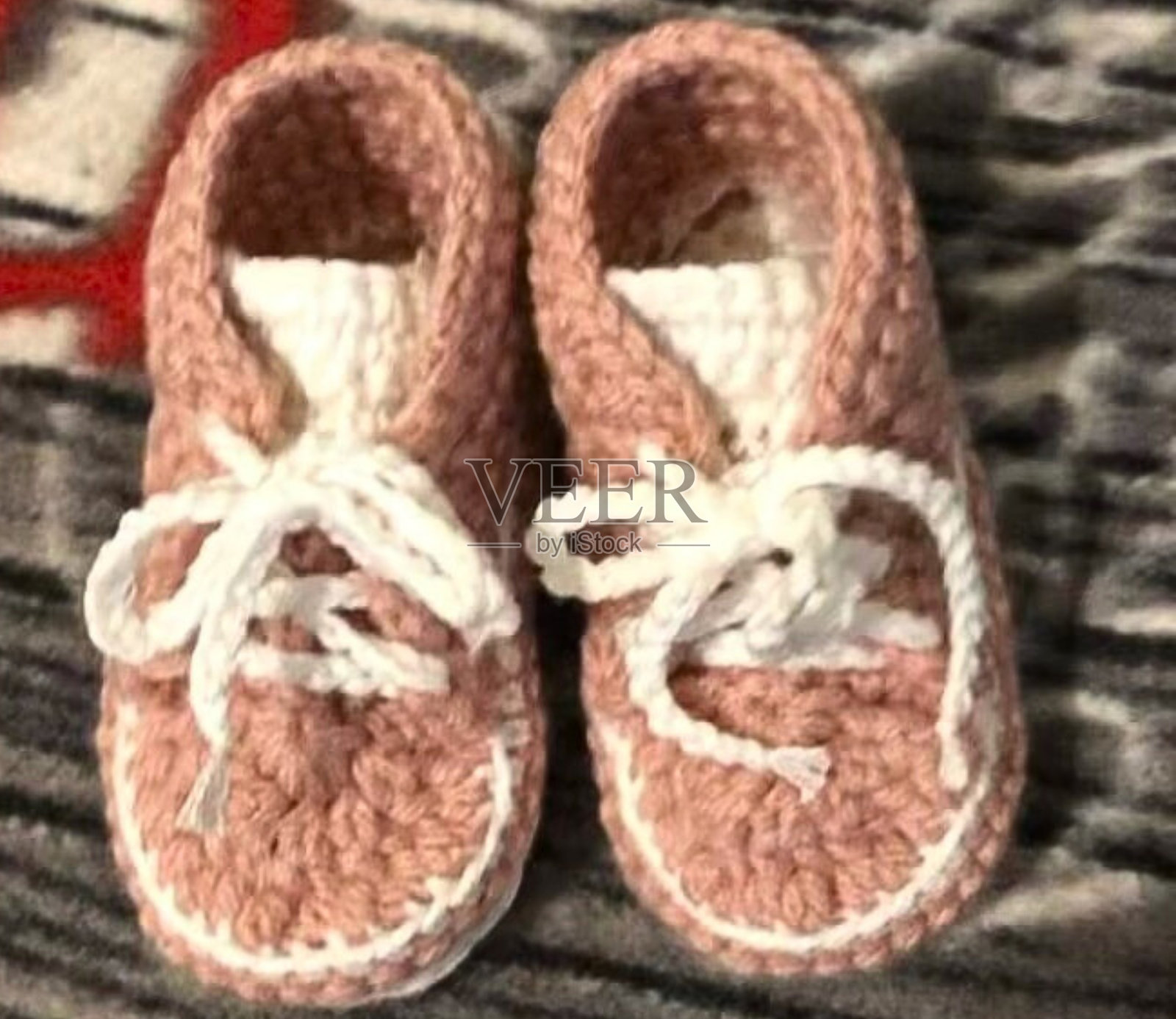 特写钩针婴儿靴在粉红色与白色鞋带照片摄影图片