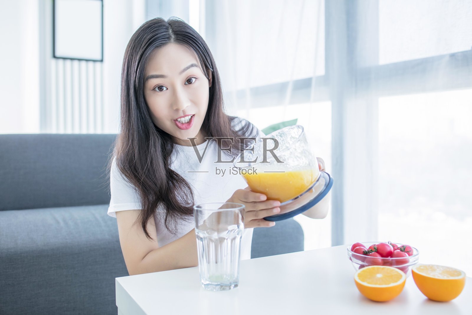 亚洲女人在厨房做橙汁照片摄影图片