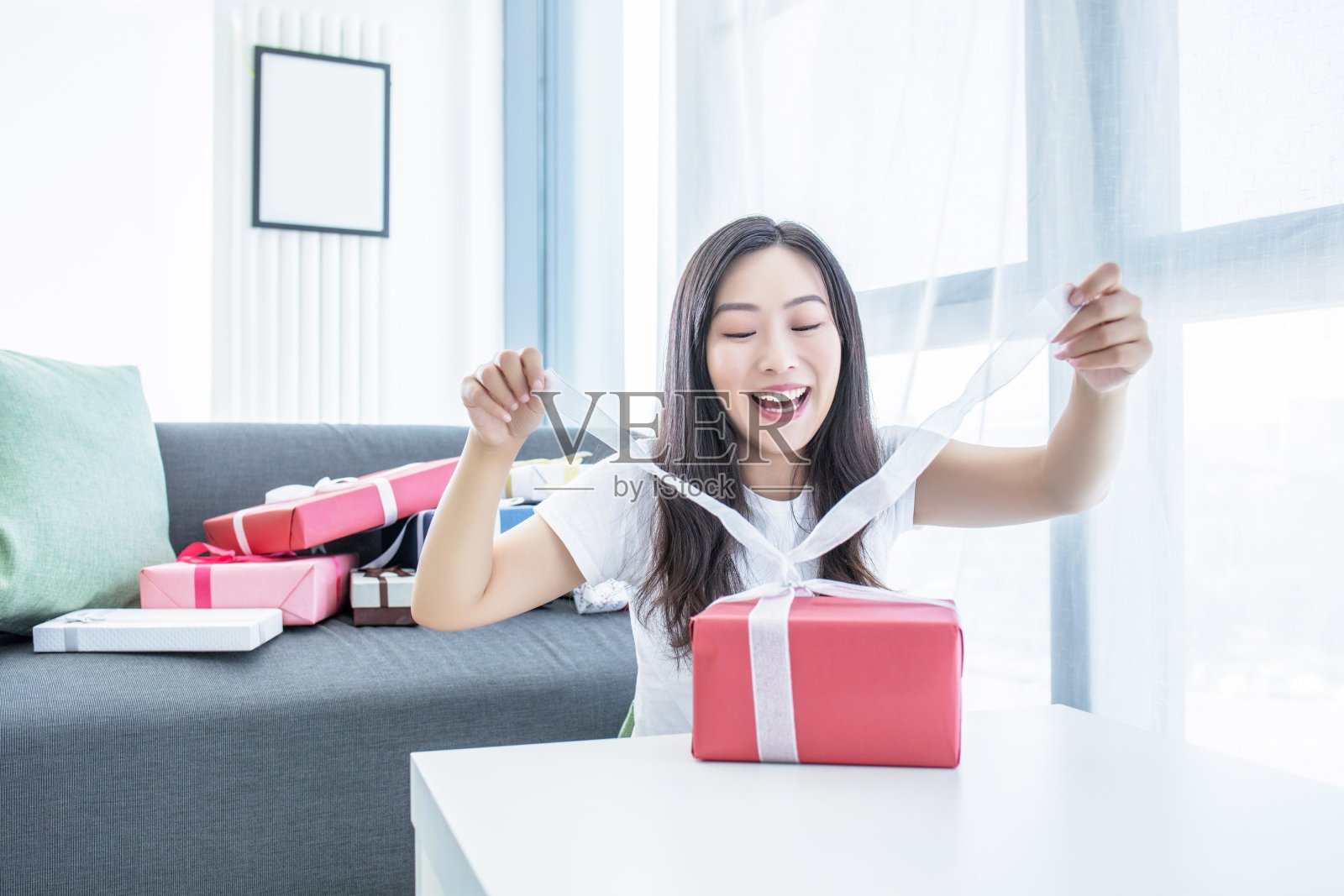 一位女士面带微笑地打开礼物照片摄影图片