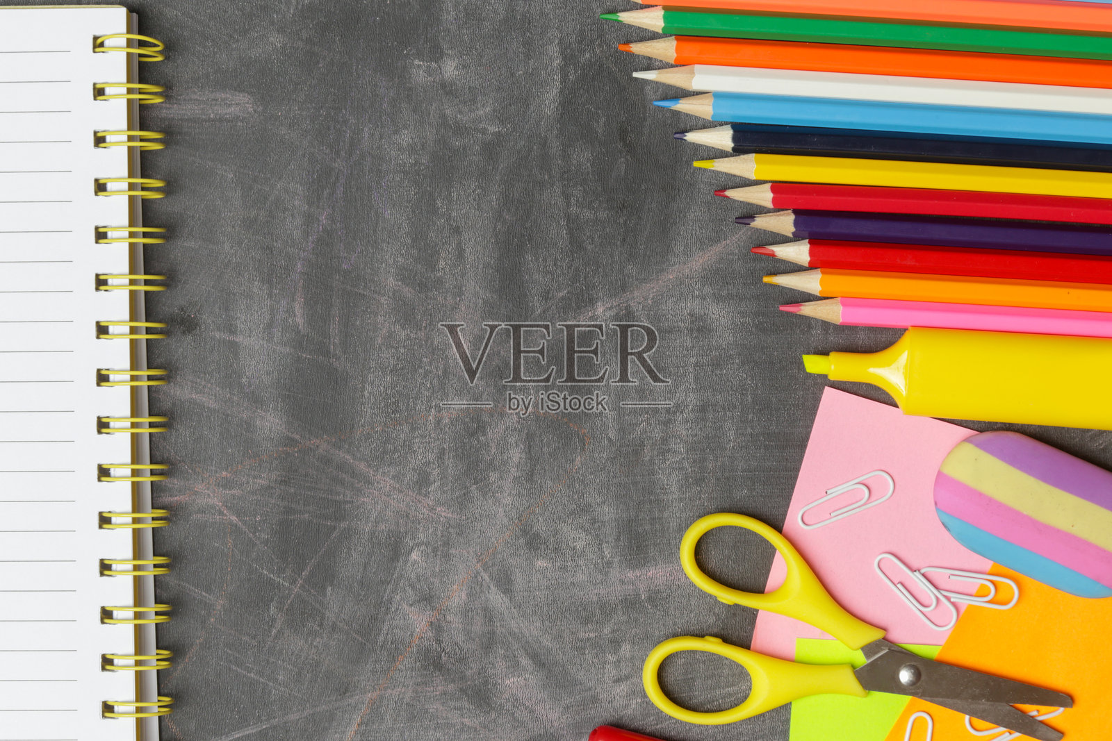 回到学校的概念，各种办公和学习用品在黑色黑板的背景。照片摄影图片