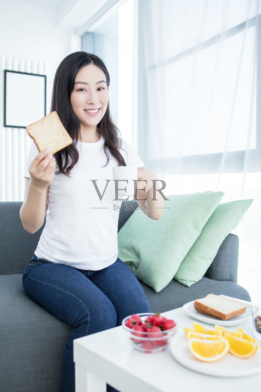 一位年轻女子正在家里吃早餐照片摄影图片