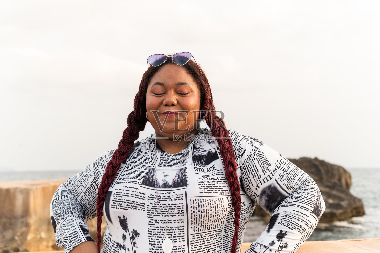 可爱的拉丁女人，梳着辫子，对着镜头害羞地微笑照片摄影图片