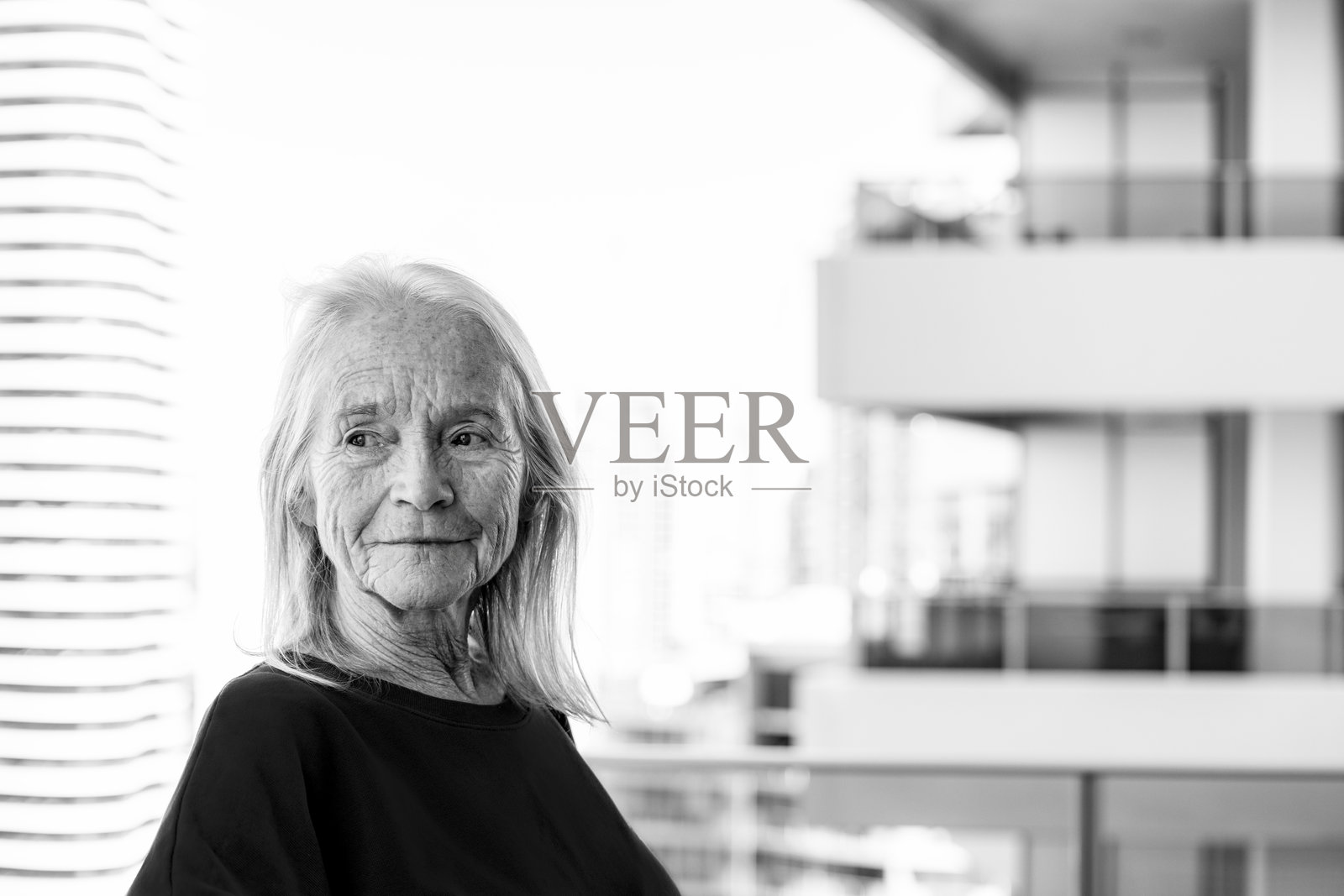 黑白肖像快乐，微笑的高级妇女在阳台上，正面视图，背景与复制空间照片摄影图片