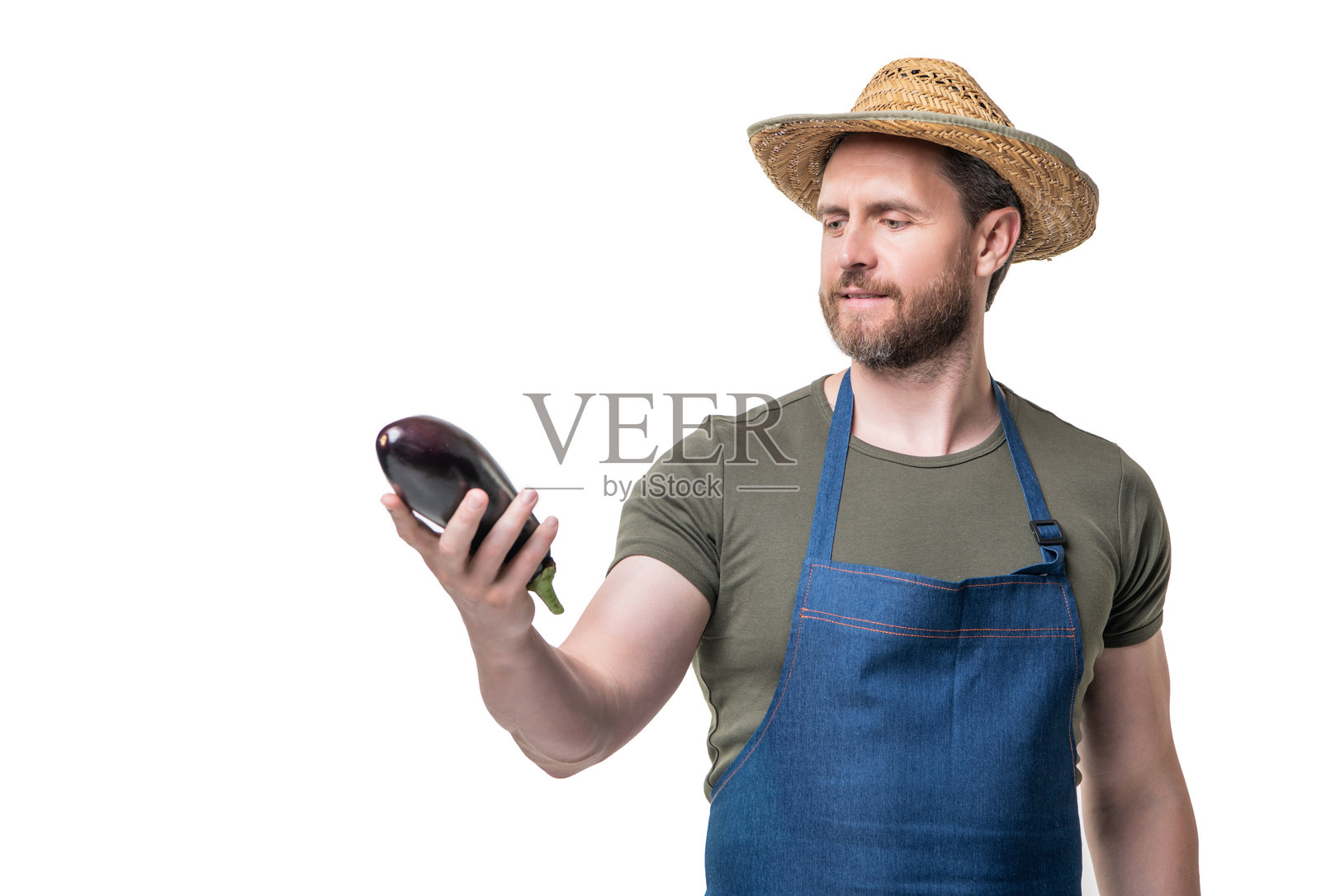 蔬菜水果商在围裙和帽子与茄子蔬菜隔离在白色照片摄影图片