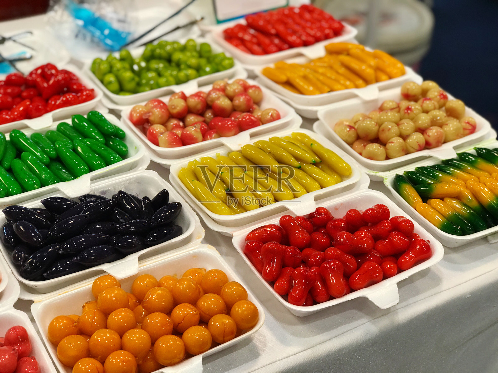 在街市出售的塑料盒彩色糖果。照片摄影图片