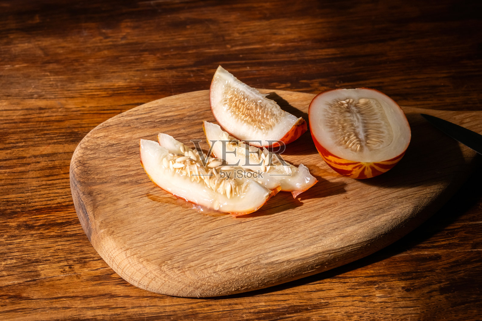 新鲜切片的越南甜瓜水果放在木制砧板上。照片摄影图片