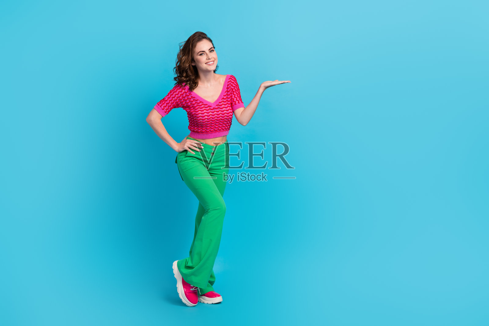 可爱的女士穿着时尚的衣服，在蓝色的背景下呈现出空旷的空间照片摄影图片