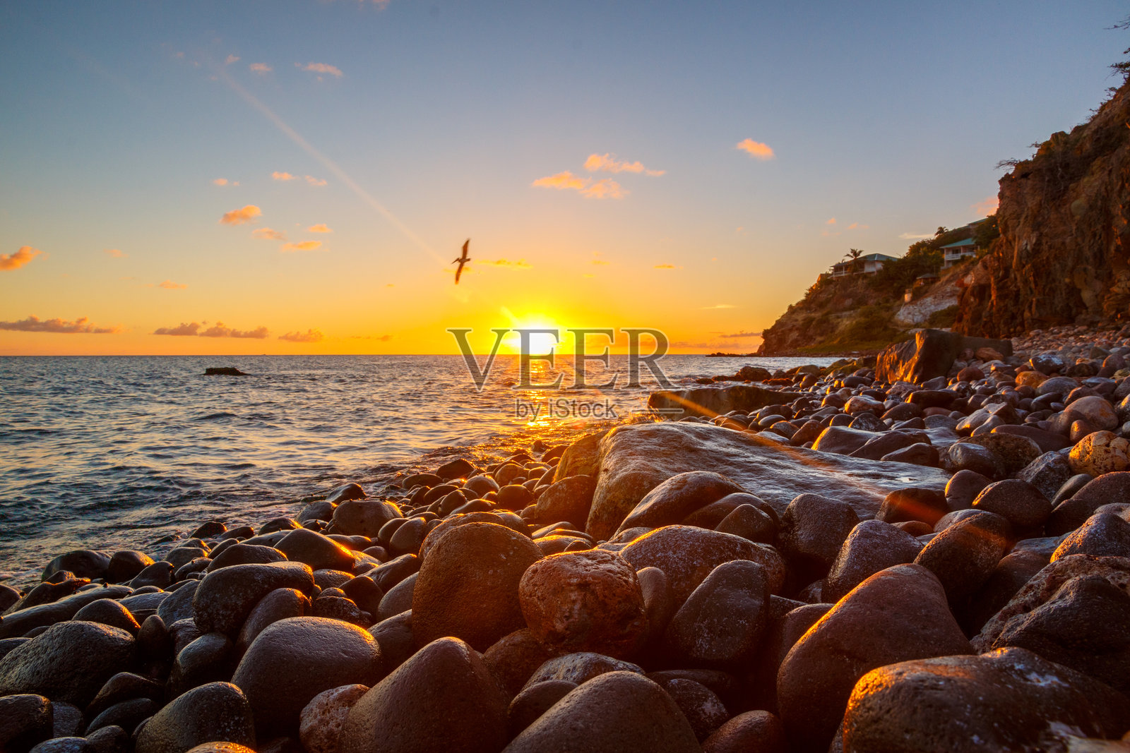日落时沙滩上的鹅卵石对着天空的特写照片摄影图片