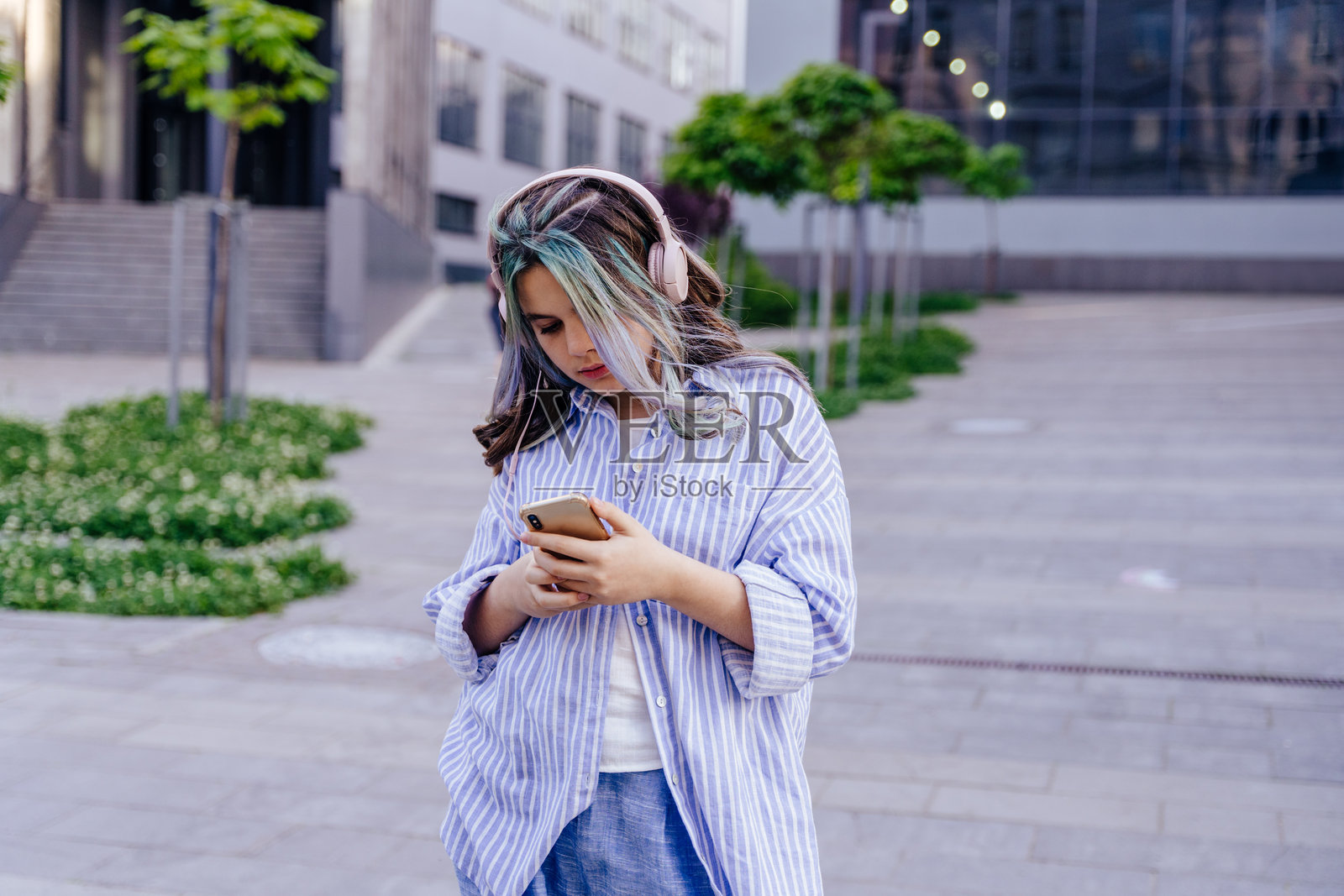女孩戴着耳机和智能手机听音乐在户外跳舞的照片照片摄影图片
