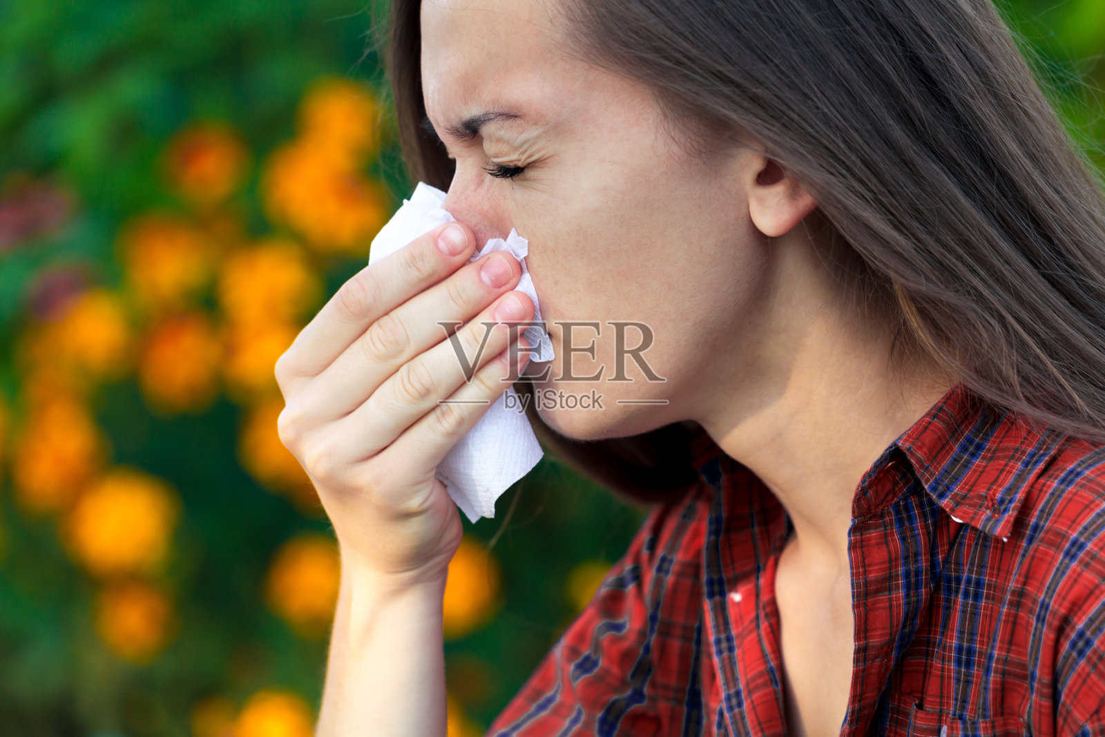 对开花植物过敏。女人用纸巾打喷嚏，流鼻涕，花粉过敏照片摄影图片