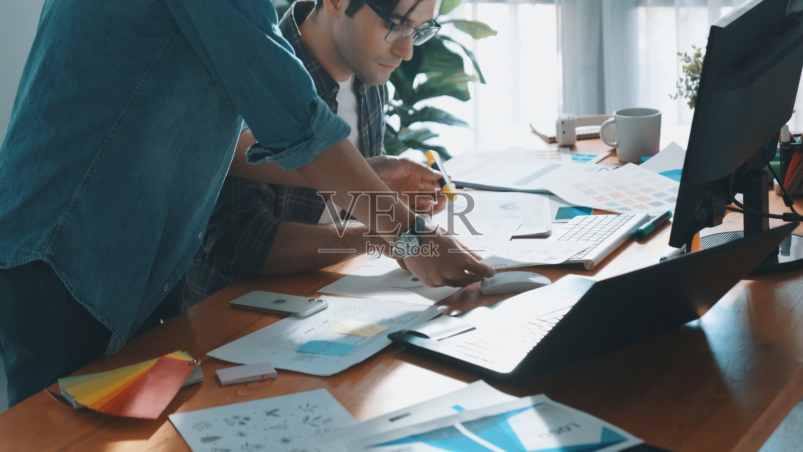 顶视图的经理看着屏幕，而设计师写的想法。研讨会。照片摄影图片