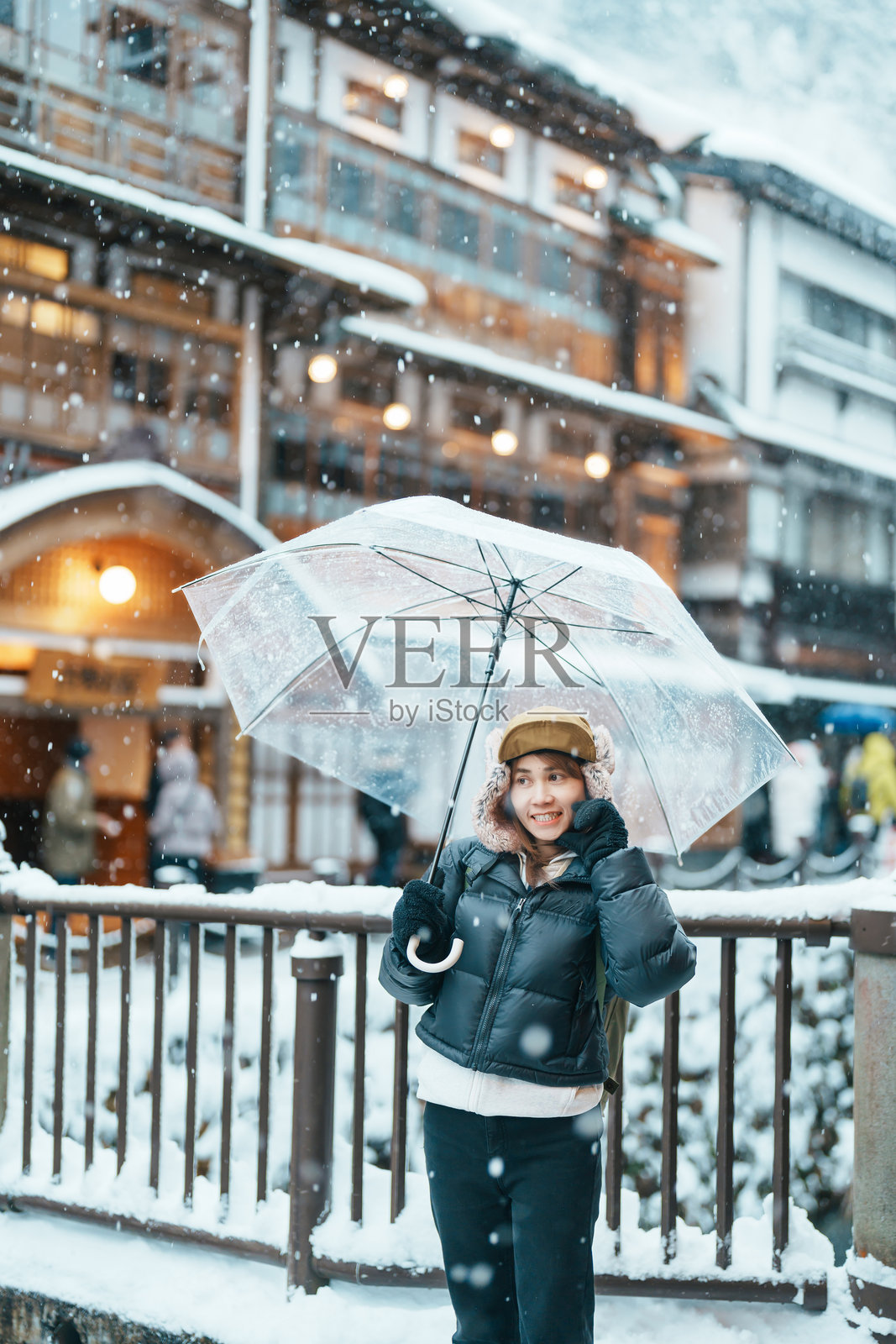 参观山形银山温泉的女游客，在冬天的雪中愉快地游览日本温泉村。它是日本的地标和著名景点。旅游度假概念照片摄影图片