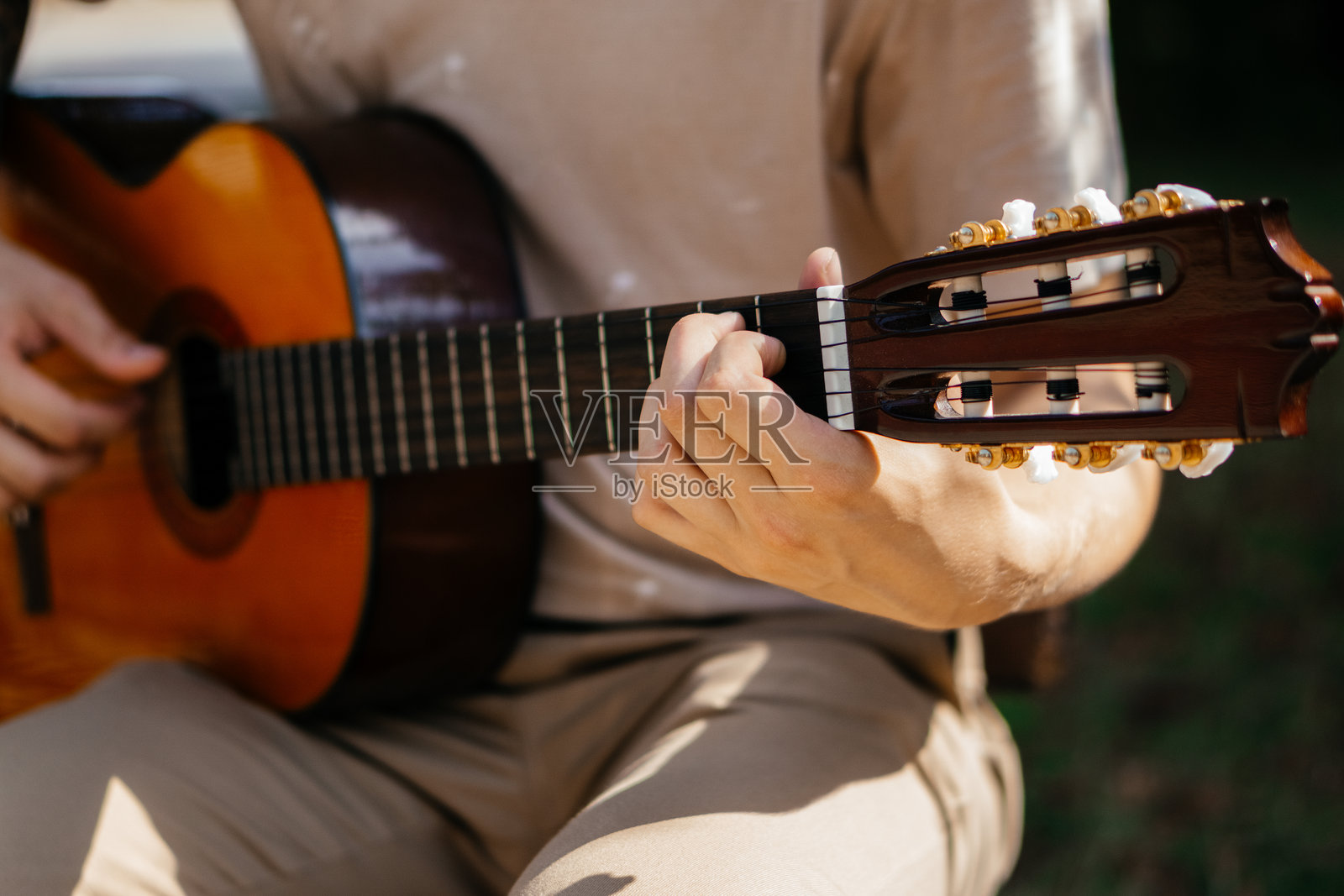 一个年轻人在外面弹原声吉他照片摄影图片