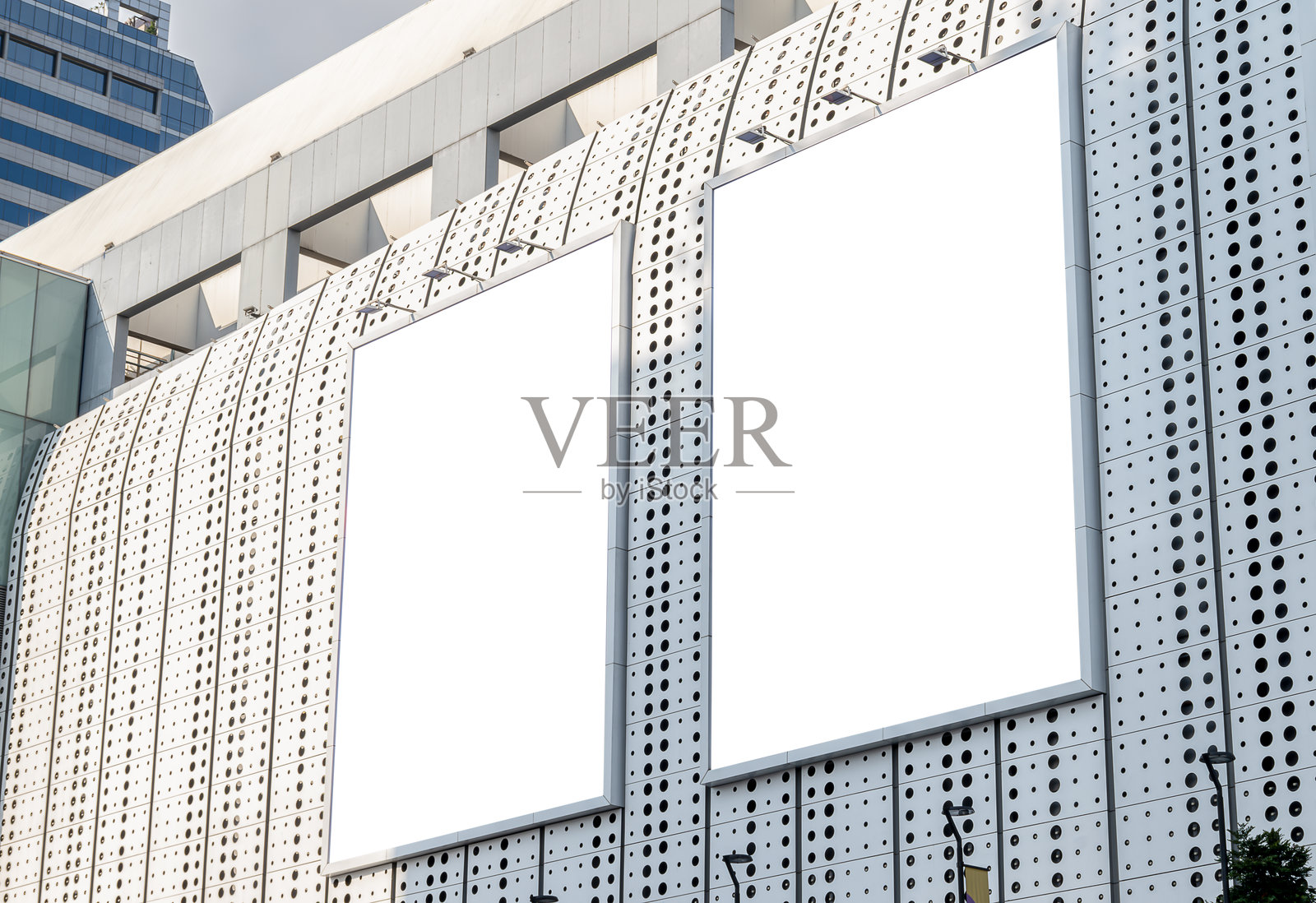 商场大楼上的两个模拟白色垂直大型LED显示屏广告牌。模型的剪辑路径照片摄影图片