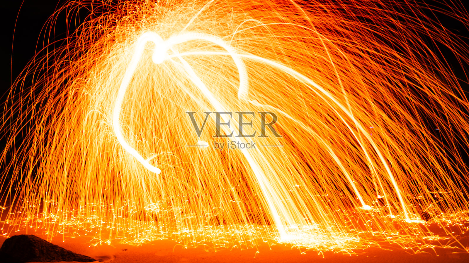 摇摆火漩涡钢丝绒光摄影在石头上与反射在水中美丽的光在日出或日落的时间，长曝光速度的运动风格照片摄影图片