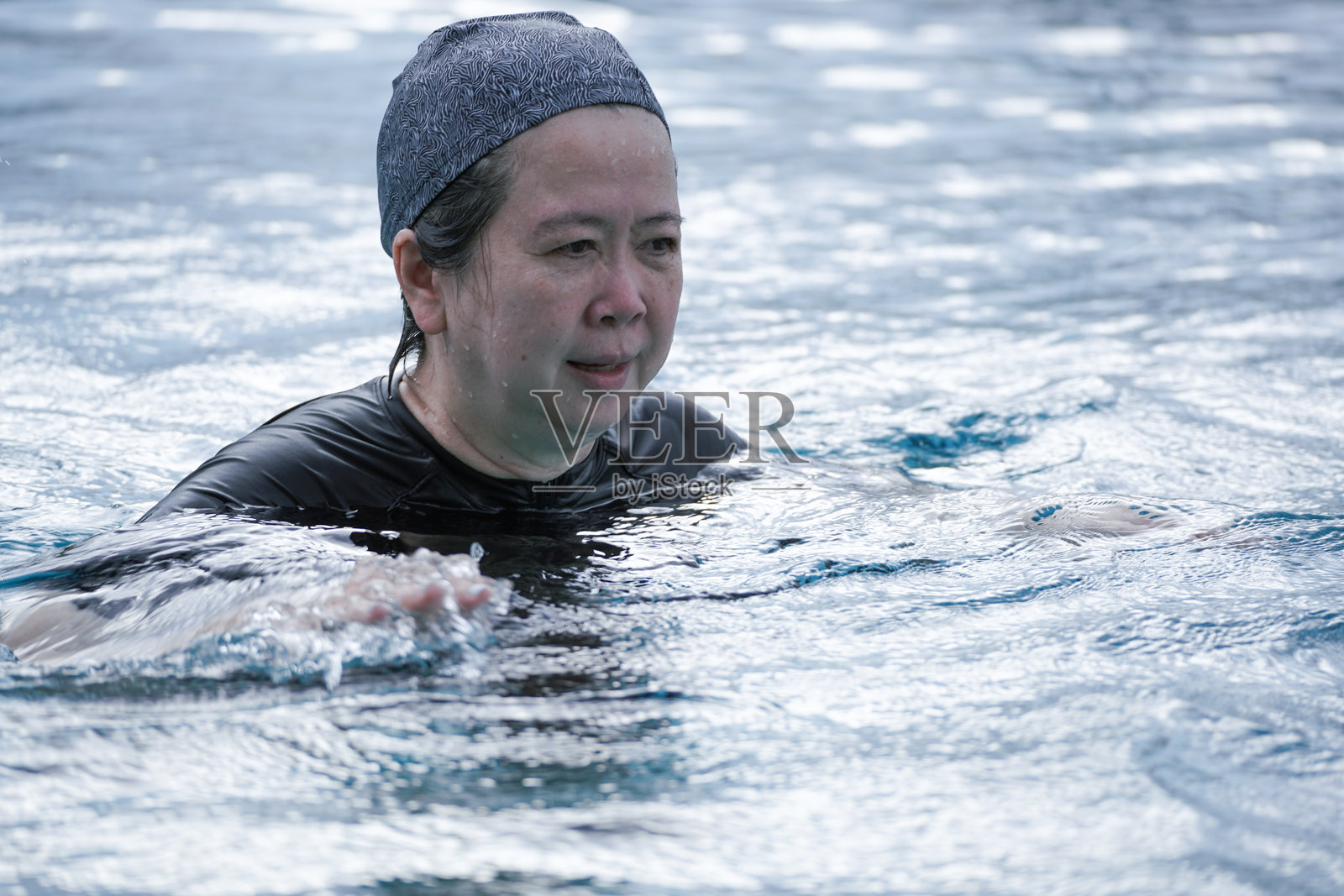 老年女性在游泳池中锻炼游泳照片摄影图片