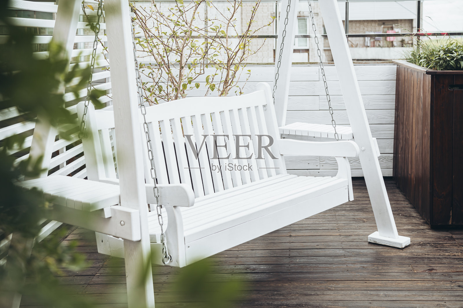 咖啡馆露台上的白色木秋千，休息的长椅。照片摄影图片