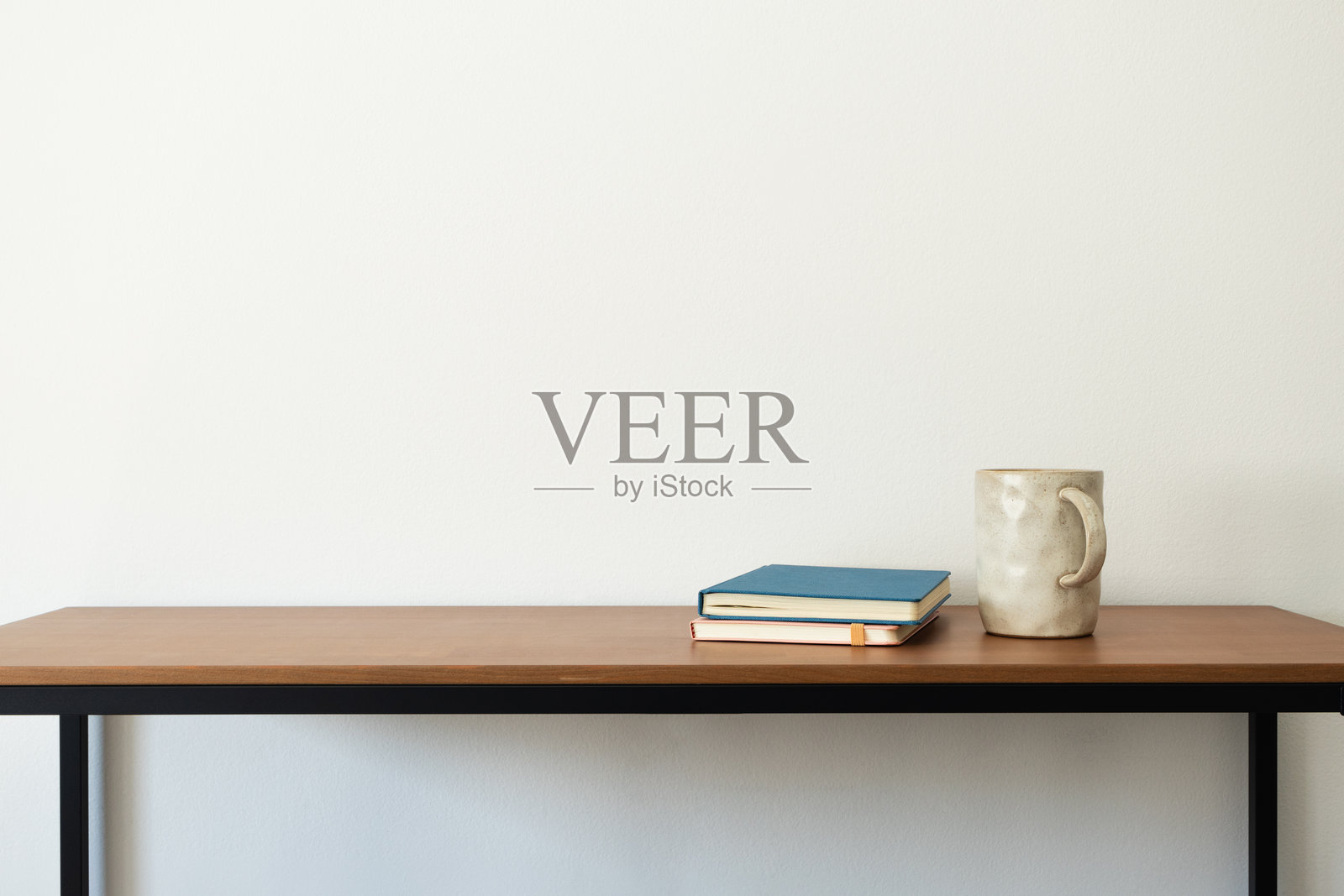 木桌上摆放着书籍和咖啡或茶，室内极简主义美学。记事本，个人日志，写作空间照片摄影图片