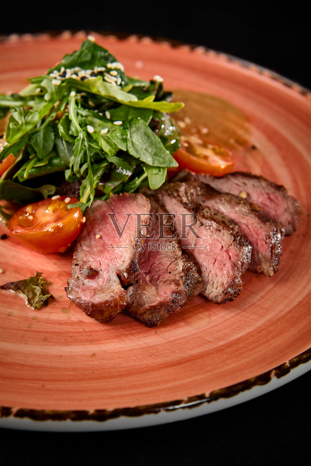 烤牛肉配西红柿和芝麻菜，质朴的盘子照片摄影图片