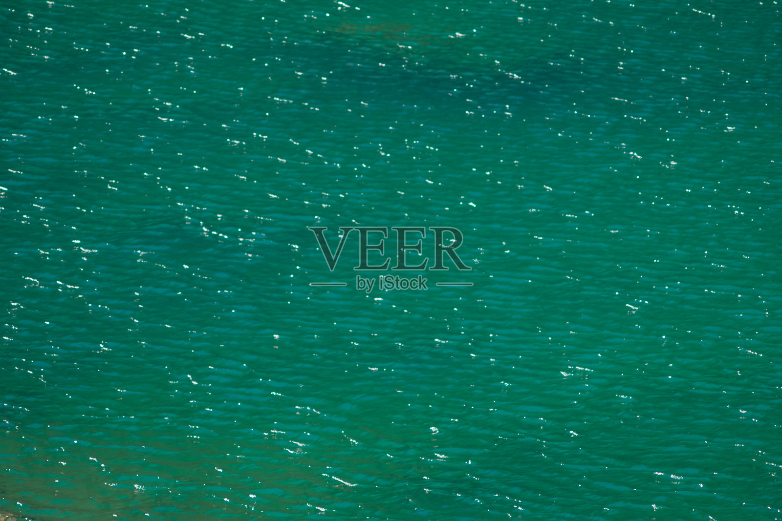 在一个平静的下午，温柔的海浪反射在宁静的绿松石海洋上照片摄影图片