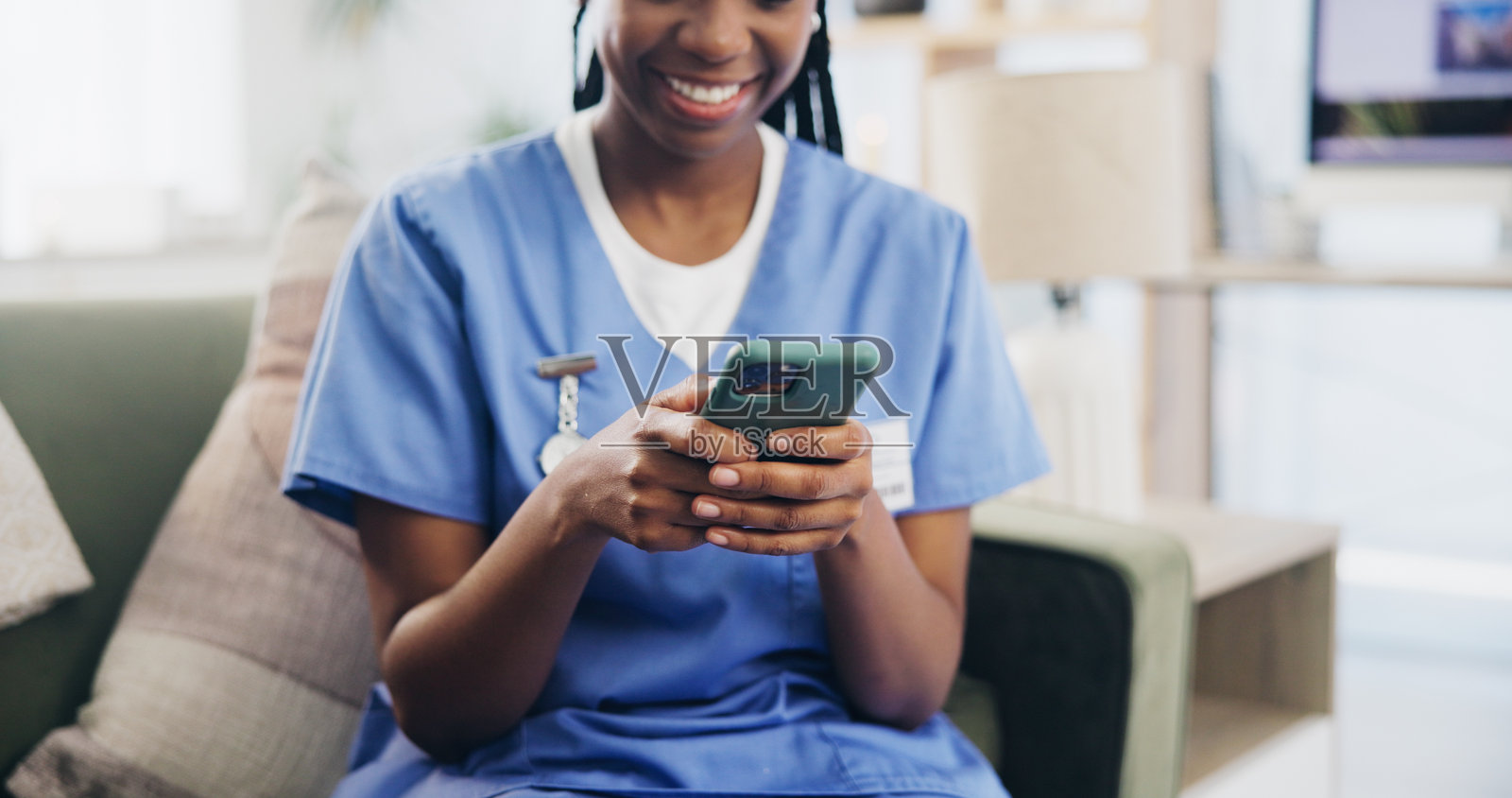 在家里发短信、发邮件或发消息时，沙发上放着人的手、护士或电话。看护者，在客厅移动或微笑获取医疗信息，聊天或开心获取医疗突破照片摄影图片