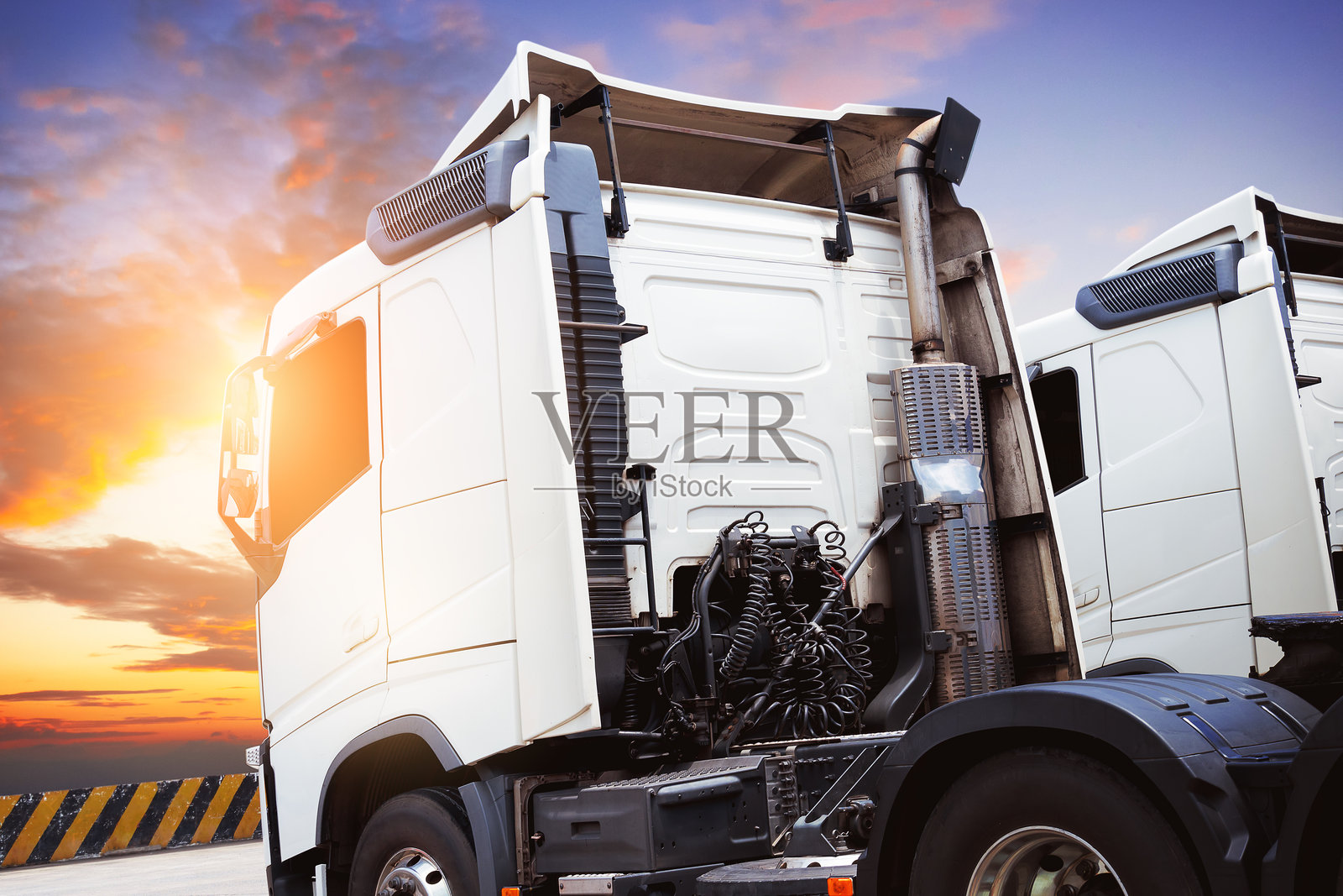 停车场的半挂车和日落。牵引车。卡车运输。柴油卡车。货运物流运输。照片摄影图片