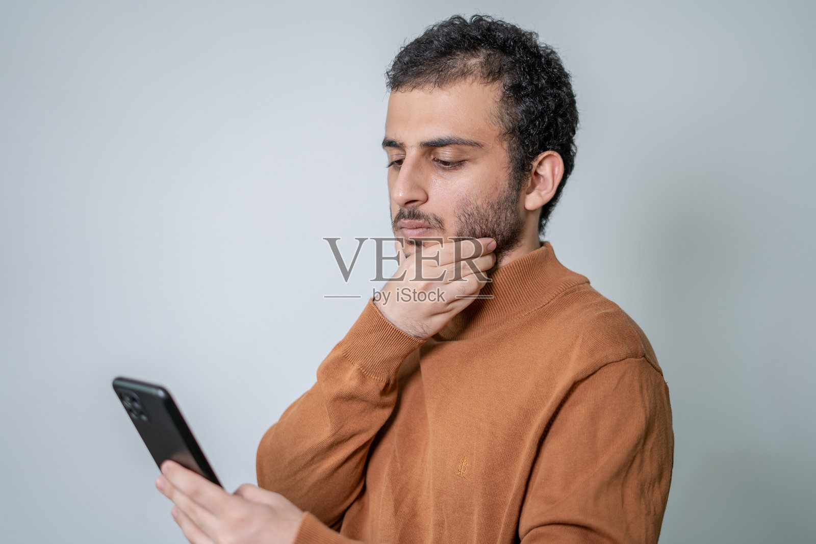 男人看着智能手机-工作室肖像照片摄影图片