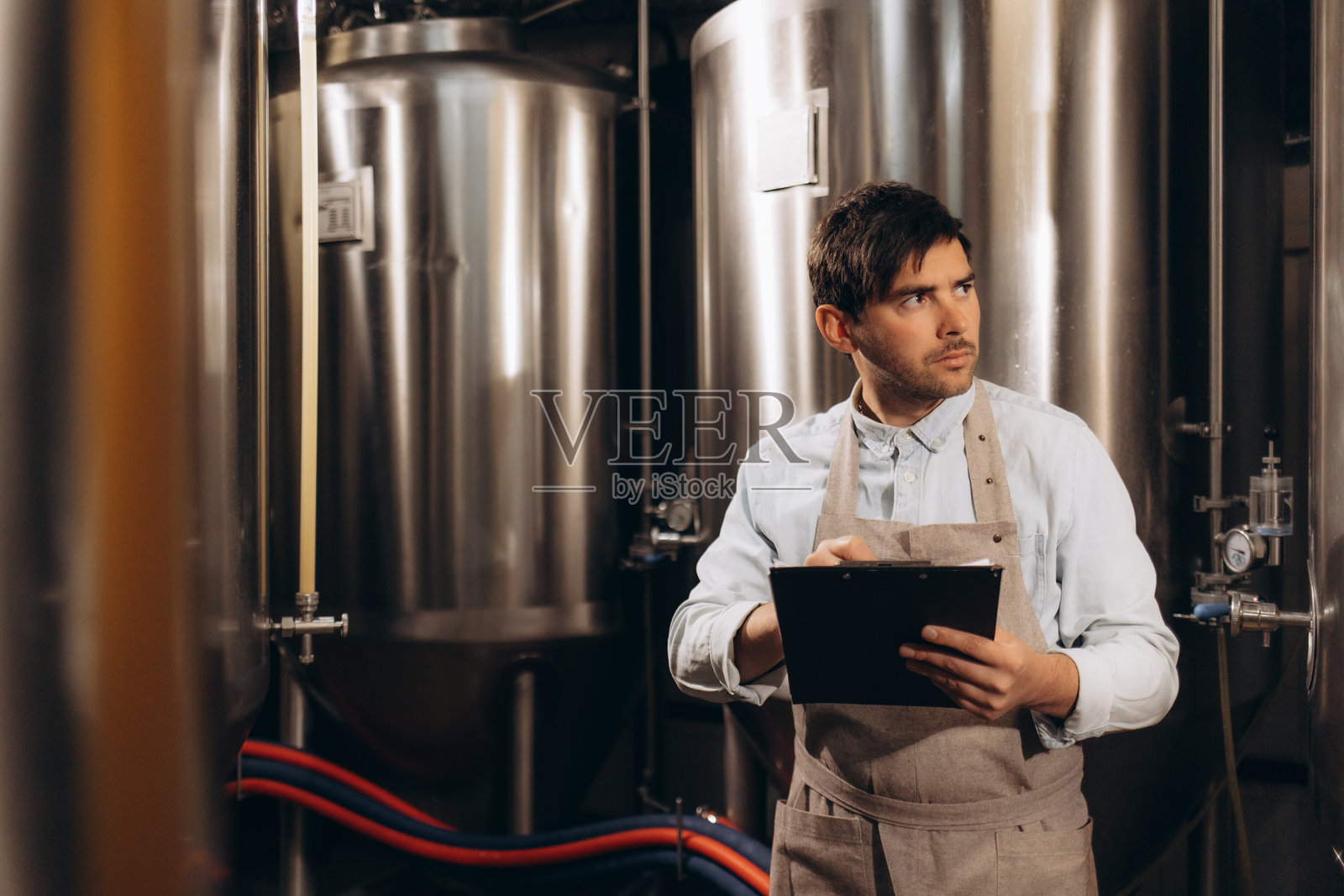 男子在酿酒厂记录酿造过程的笔记照片摄影图片
