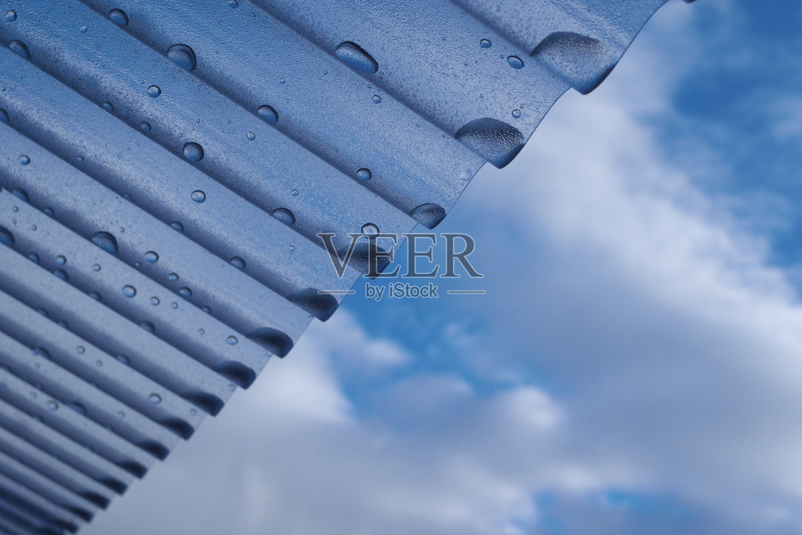 波纹塑料屋顶与蓝天背景下的水滴照片摄影图片