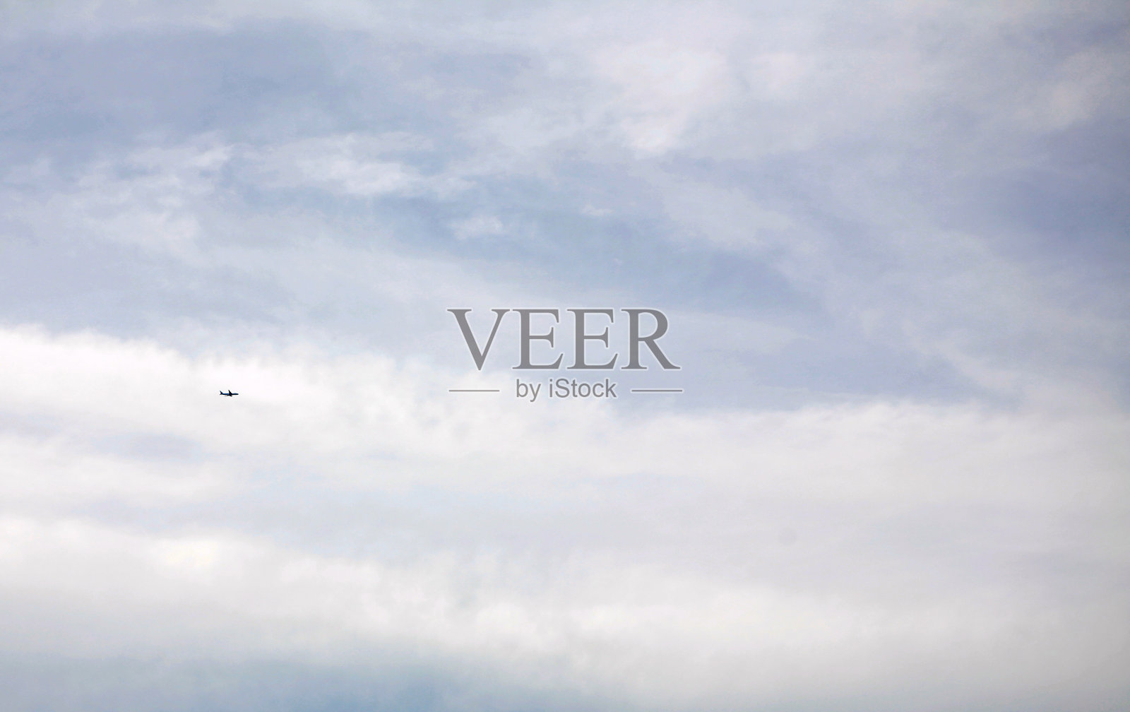 一架飞机在多云的天空中飞行照片摄影图片