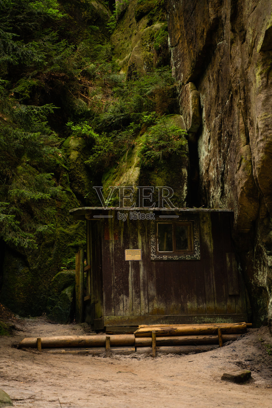 自然公园中的小木屋，周围有高耸的悬崖和岩石照片摄影图片