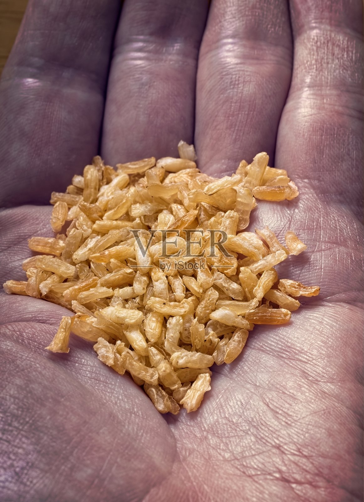 人手握着一堆棕色大米粒照片摄影图片